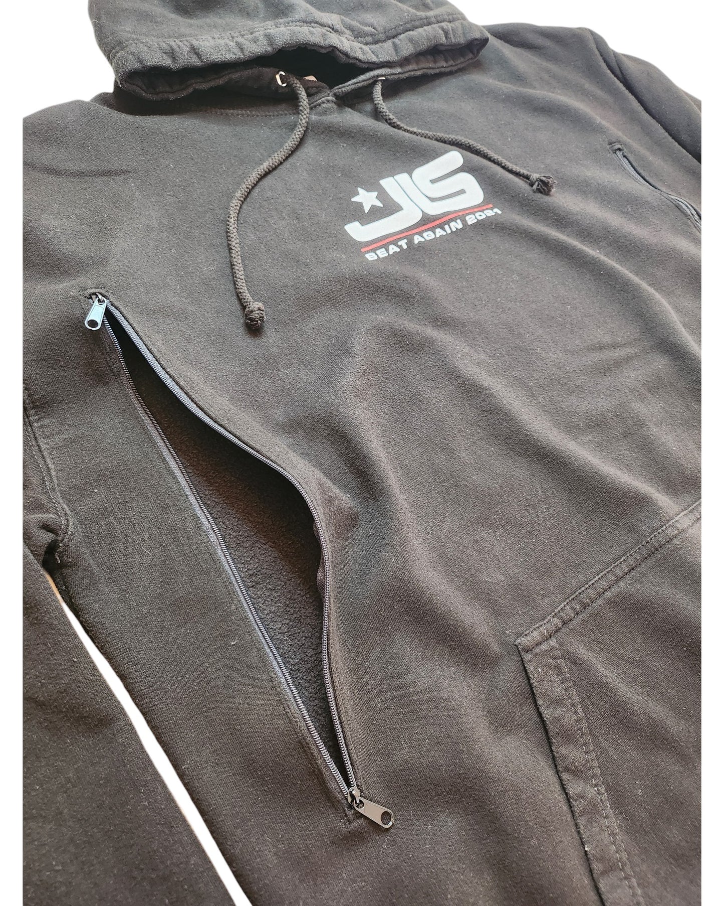 This touch out mama XXL hoodie in black, made from upcycled materials, features a front pocket and diagonal zipper. The chest sports JG with a star and the text BEAT AGAIN 2024 in white and red.