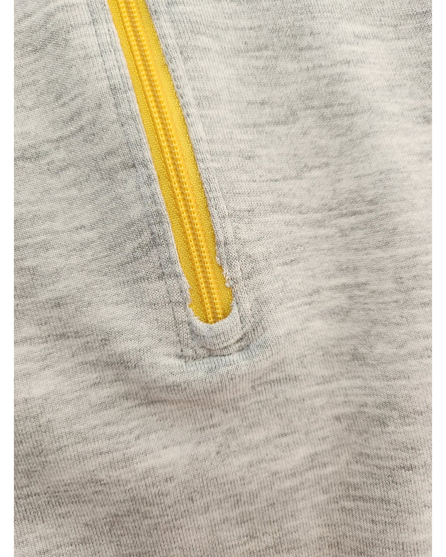 A gray fabric from the Upcycled Breastfeeding & Pumping Feeling Good Sweatshirt UK22 by touched out mama features a bright yellow zipper. The partially open zipper reveals neat stitching on this soft, slightly heathered material, celebrating sustainable style with every detail.