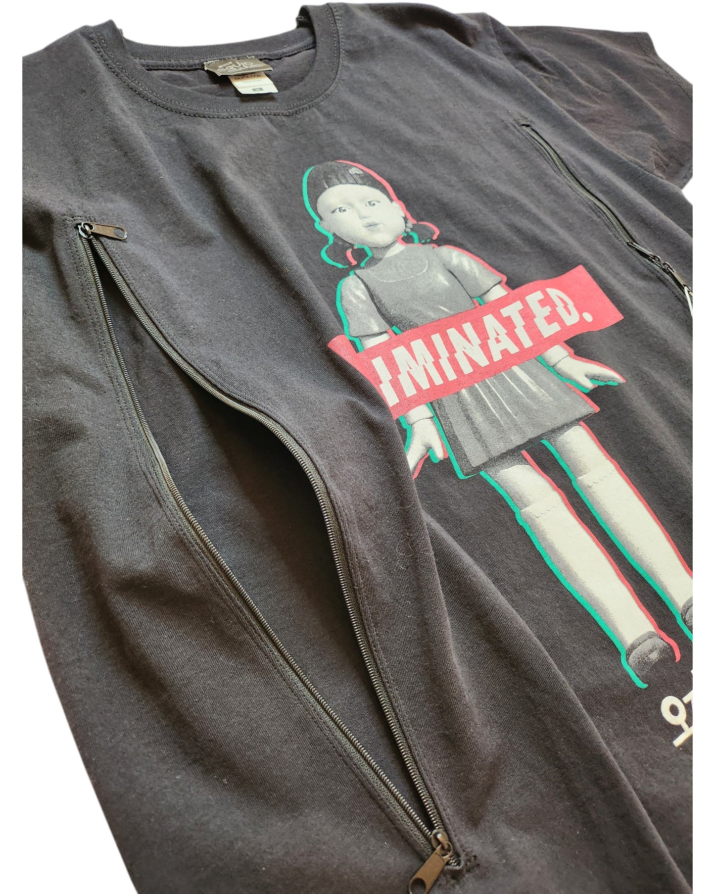 The Upcycled Breastfeeding (Nursing) & Pumping Squid Games T-shirt by touched out mama features a doll graphic in red and green with a bold ELIMINATED banner. Made from upcycled materials, this unique piece has zippers on both sides for an edgy flair.