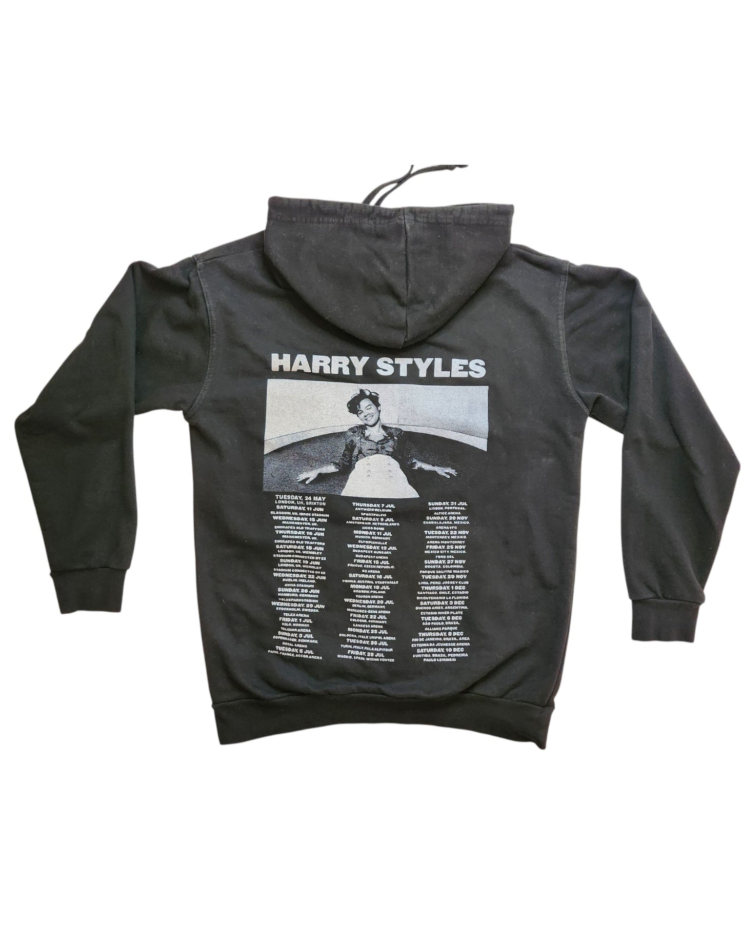 The Upcycled Breastfeeding & Pumping Harry Styles Hoodie M by touched out mama is an eco-friendly black hoodie featuring a photo with outstretched arms and HARRY STYLES text. Below the image, it showcases a list of tour dates and locations.