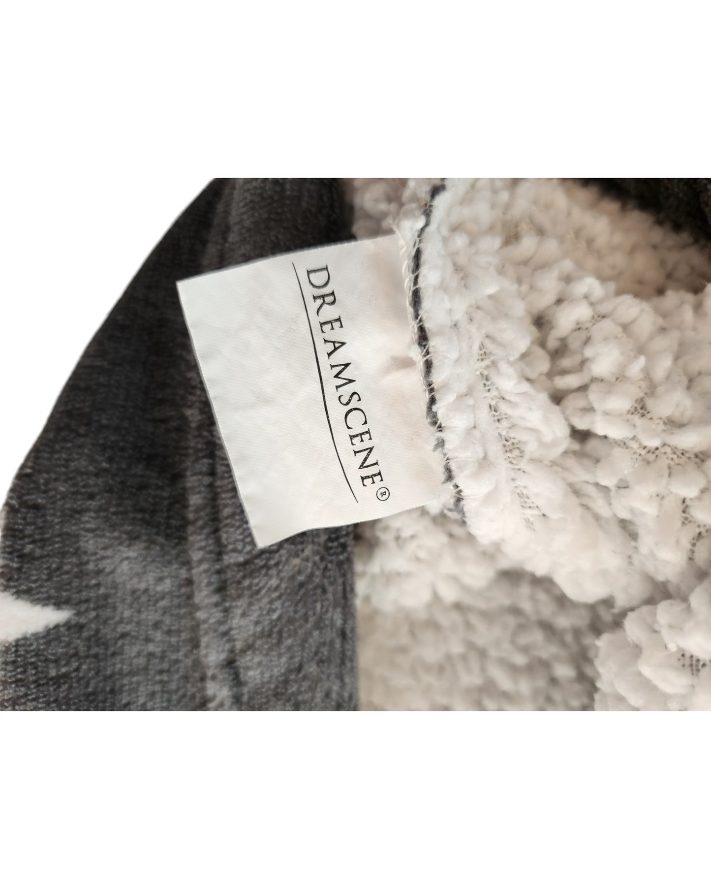 Close-up of a fabric tag with touched out mama on it, attached to the soft, fluffy material of an Upcycled Breastfeeding & Pumping Stars Blanket Hoodie. The texture appears warm and cozy, exuding sustainable comfort.