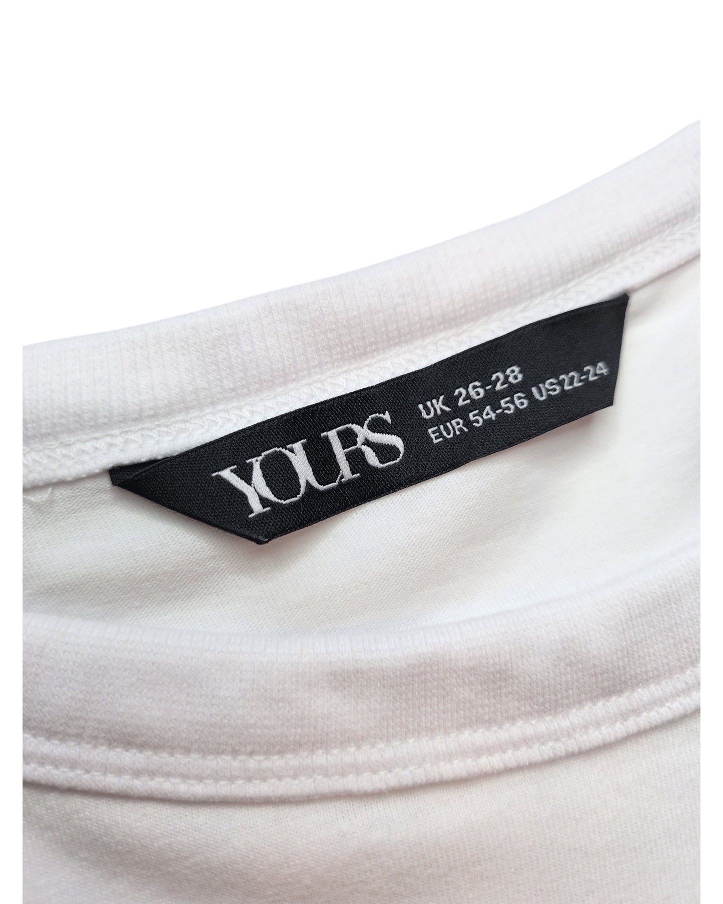Close-up of a black label with white text on a white garment showcases sizing UK 26-28, EUR 54-56, US 22-24. The label reads touched out mama, highlighting its eco-friendly fashion commitment.
