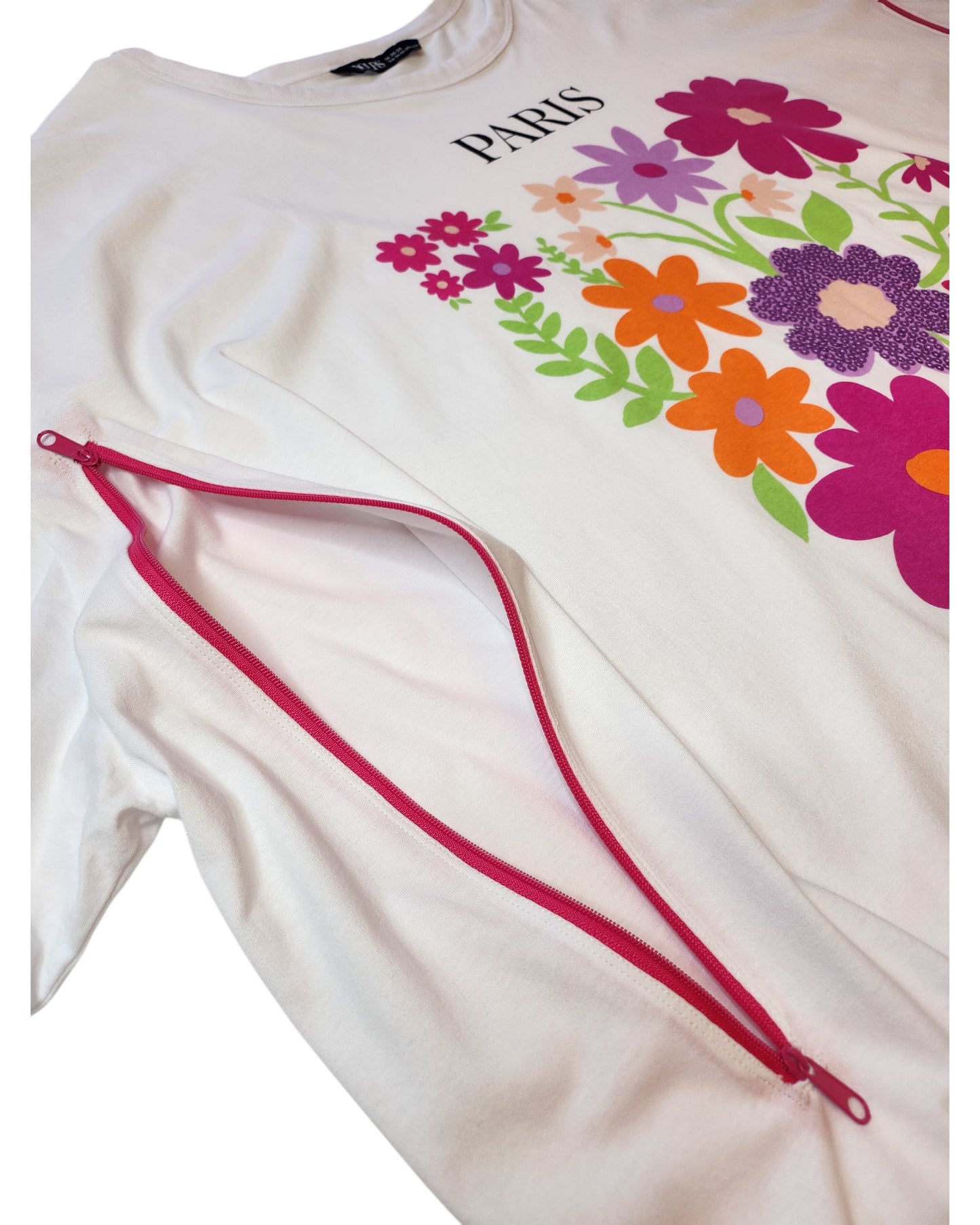 The touched out mama Upcycled Breastfeeding & Pumping Paris Floral t-shirt UK26/28 showcases PARIS text and a lively floral print, enhanced by red zippers from sleeves to hem. This eco-friendly design merges style with sustainability.