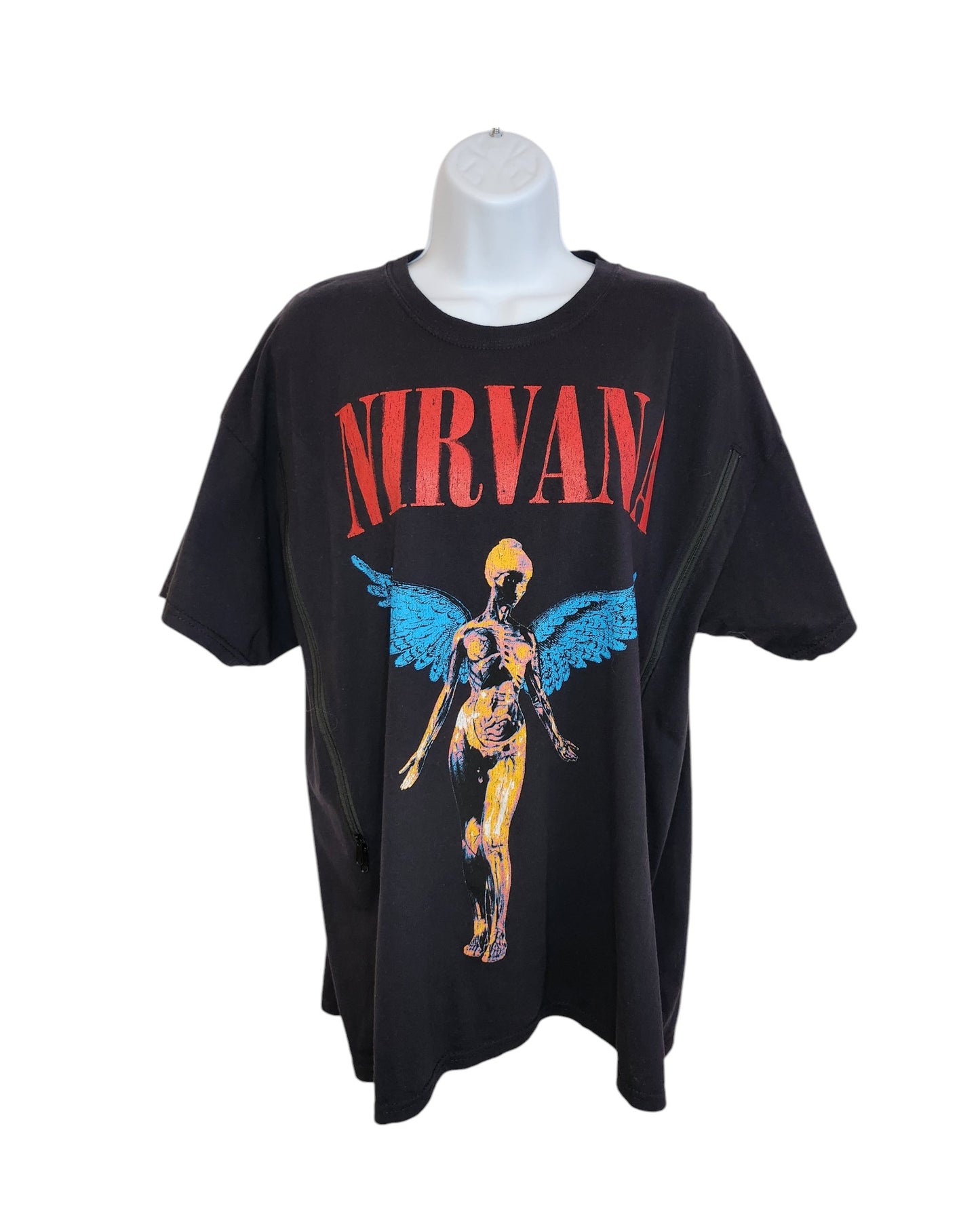 This preloved black Nirvana T-shirt from touched out mama in XL features a colorful anatomical angel with wings. The bands name is boldly printed in red above the image, adding rock edge to its upcycled charm, perfect for eco-conscious fans. Displayed on a white mannequin bust.