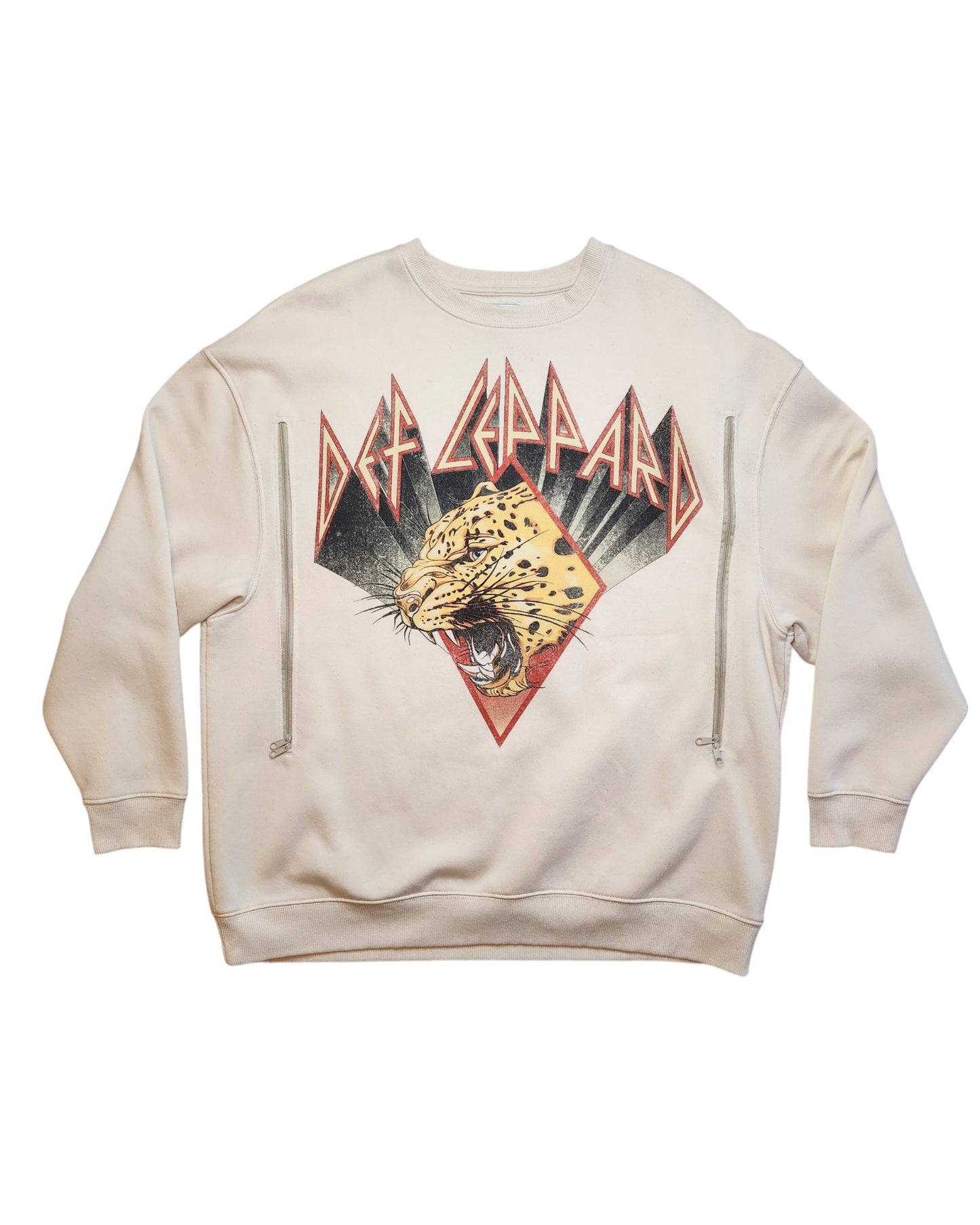 A cream sweatshirt from touched out mamas eco-friendly line features a Def Leppard graphic with a roaring leopard in a triangle and the bands name in bold, jagged letters. Its an upcycled nursing & pumping sweatshirt available in size M.