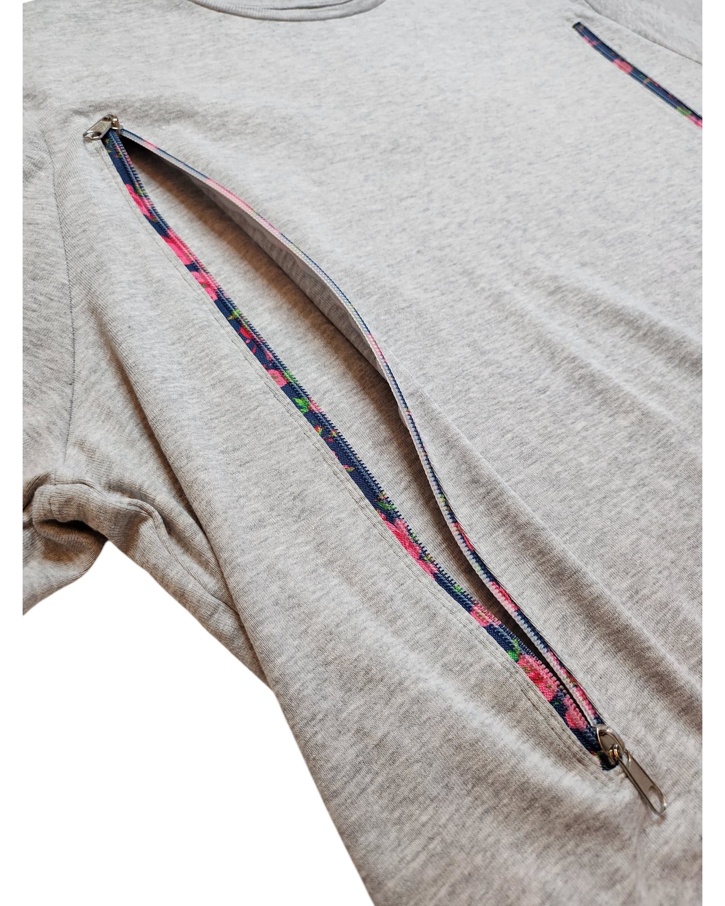 The touched out mama Upcycled Breastfeeding Grey Floral Zips T-shirt (UK24) has a diagonal zipper from sleeve to mid-torso, ideal for nursing. Its soft fabric and relaxed fit make it a perfect choice.