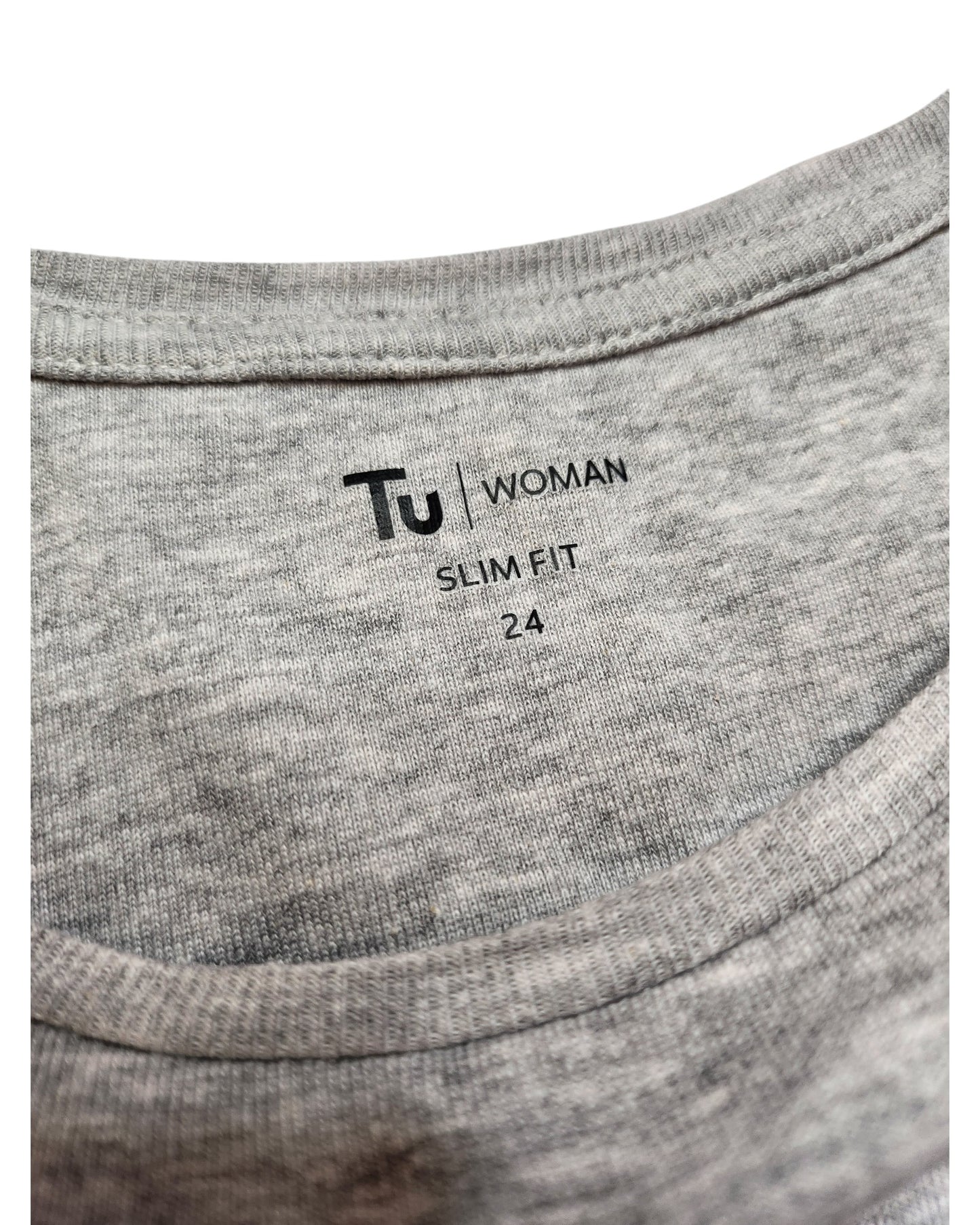 Close-up of a gray T-shirt label displaying touched out mama, featuring the text UK24 for size, and accentuating its preloved charm with fabric texture visible. The shirts name is Upcycled Breastfeeding (Nursing) & Pumping Grey Floral Zips t-shirt, laid flat with label printed directly on material.