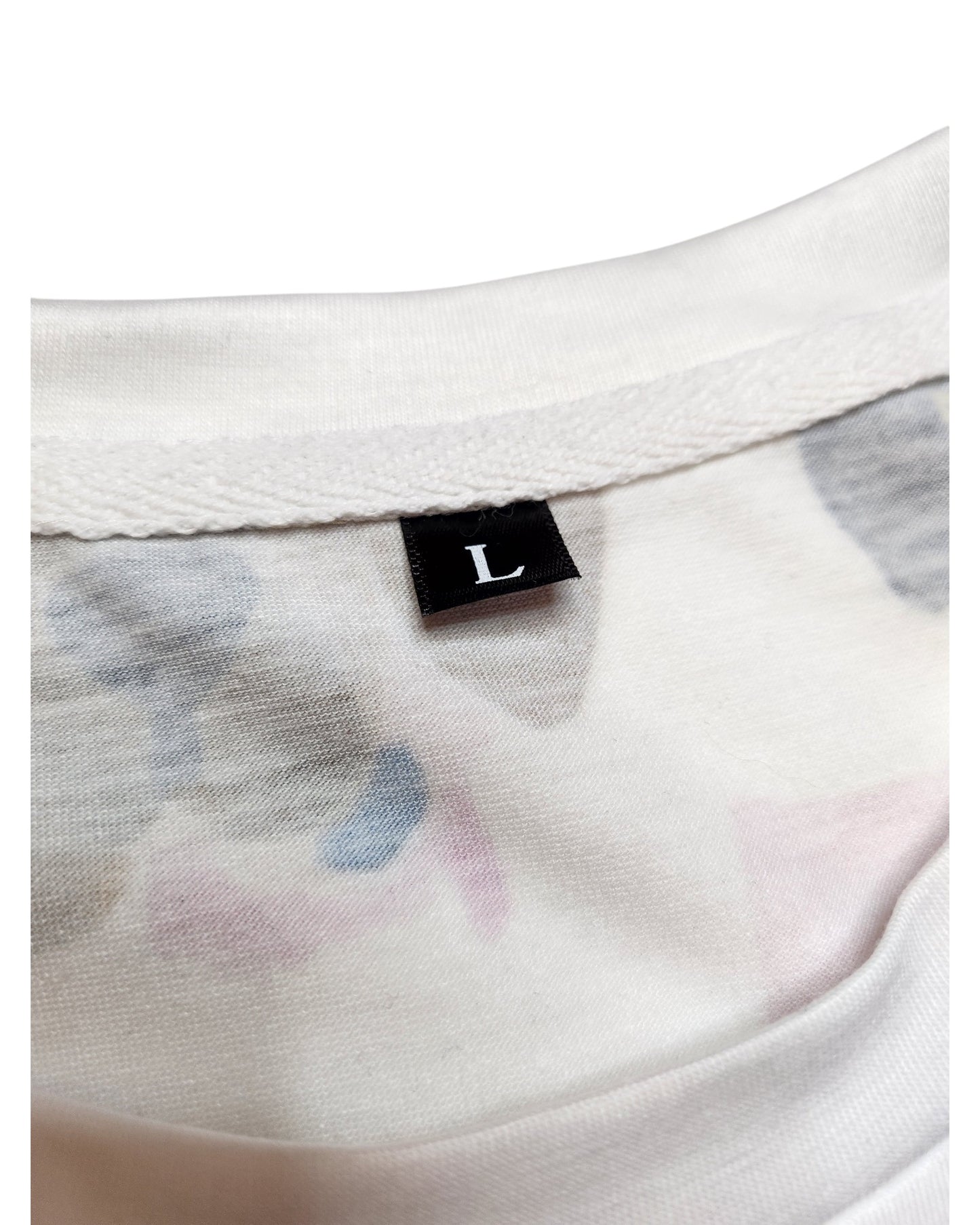 Close-up of a white t-shirt collar with a black L label for size large. This preloved Upcycled Breastfeeding & Pumping Dogs tee by touched out mama features soft, blurred pastel designs in muted blue and pink, enhancing its upcycled clothing charm.