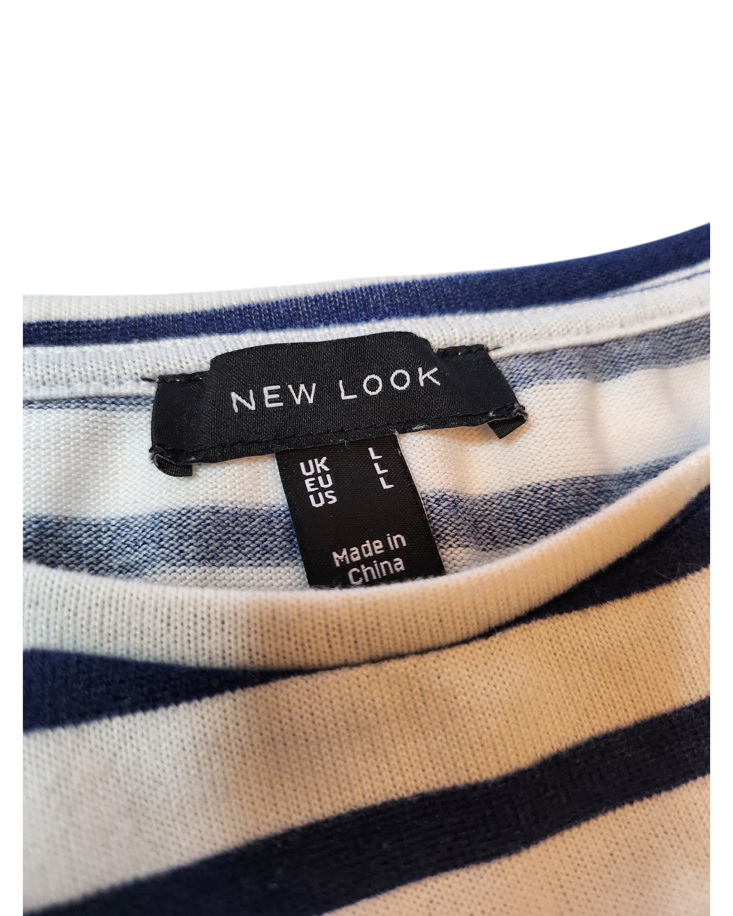 A close-up of a preloved clothing label from touched out mama featuring the Upcycled Breastfeeding & Pumping Stripe Knit Top L. The tag reads size UK L, EU L, US L and Made in China. The garment is white with dark blue stripes, offering a timeless appeal.