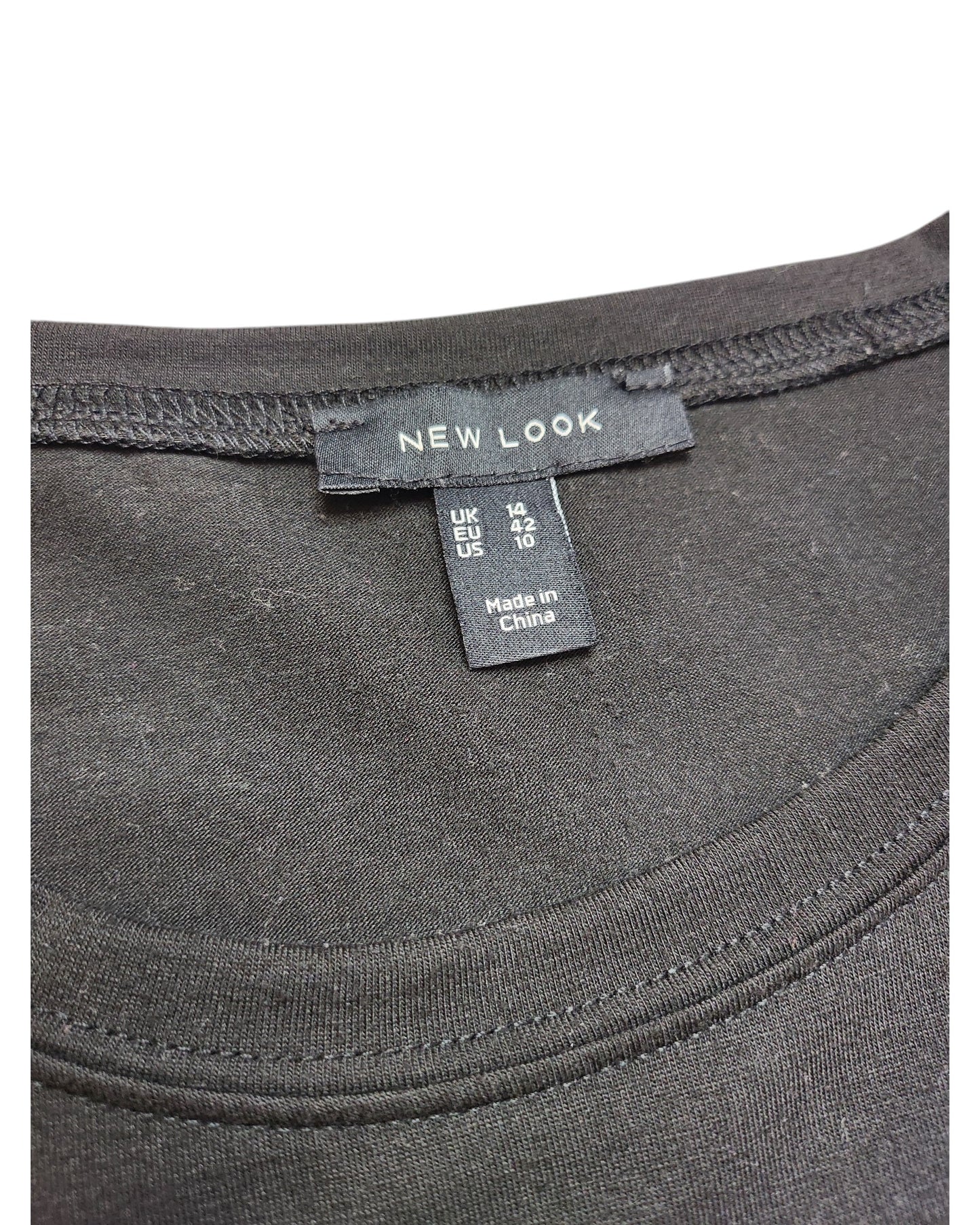Close-up of a black tulle shirt exuding preloved charm, labeled touched out mama. The size tag reads UK 14, EUR 42, US 10, MEX 10. Quality fabric and stitching hint at its origins from China.