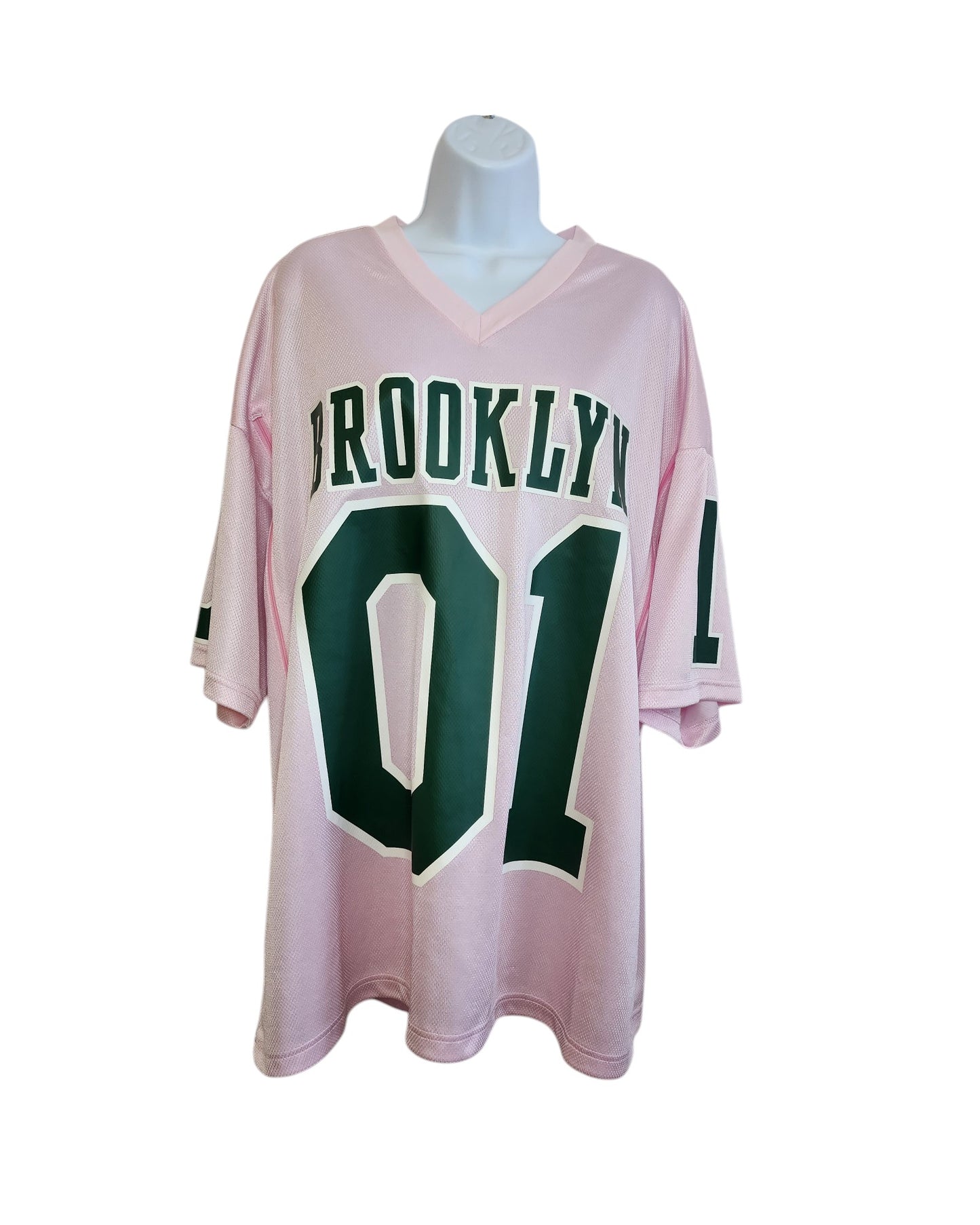 An XL H&M upcycled breastfeeding & pumping football jersey in light pink, featuring BROOKLYN and 01 in bold green on the front, is shown on a white mannequin bust against a plain white background.