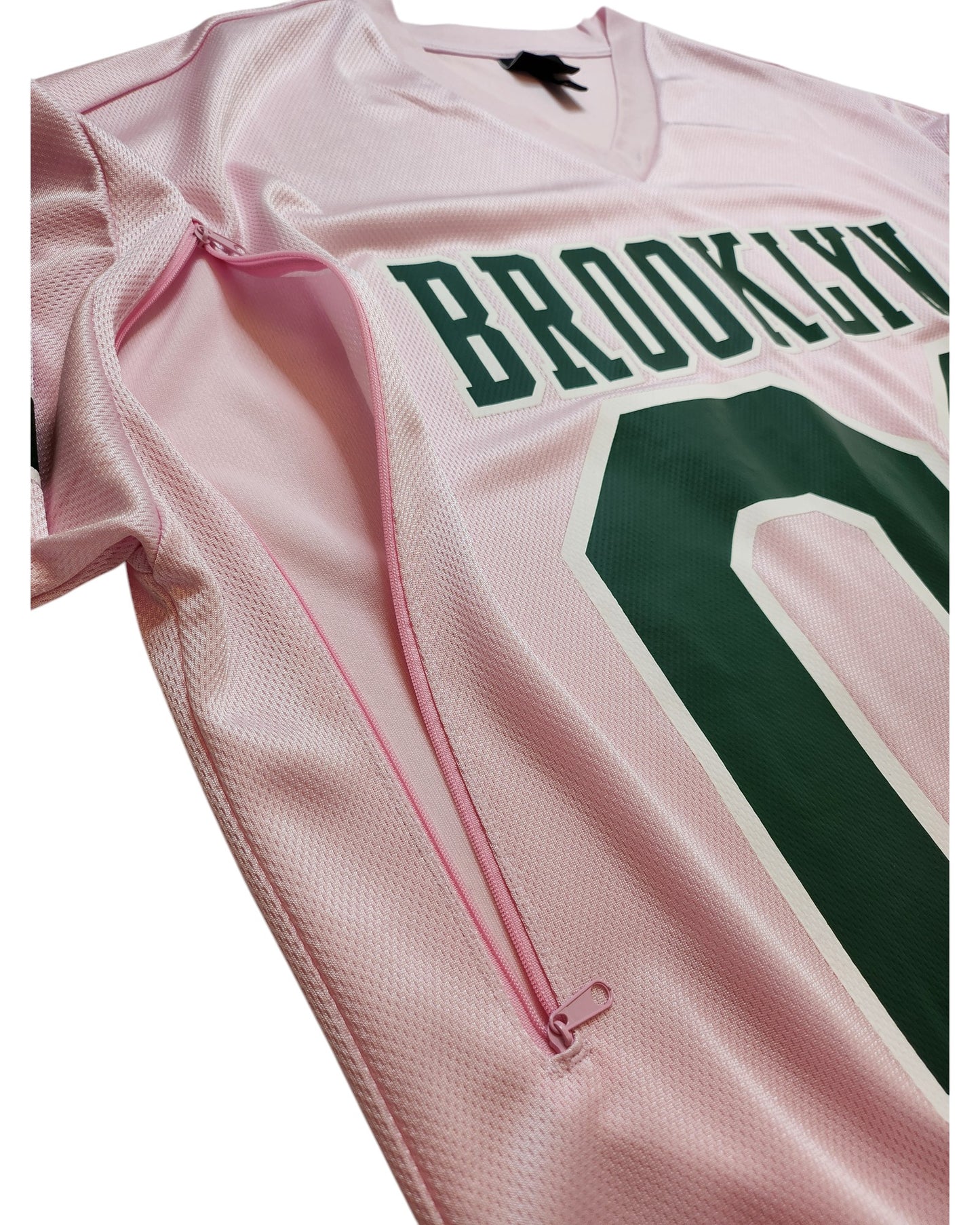 The H&M Upcycled Breastfeeding & Pumping Football Jersey XL is a pink sports jersey with BROOKLYN and 00 in green, plus a sideways pink zipper for nursing—an eco-friendly choice for breastfeeding and pumping moms.