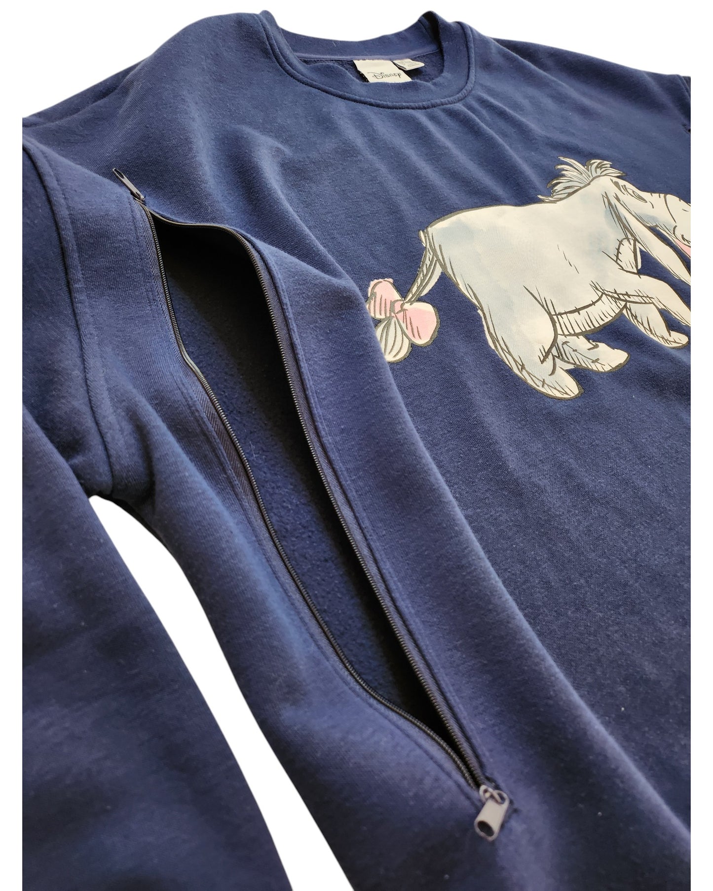 The Primark Upcycled Breastfeeding & Pumping Eeyore Disney Sweatshirt in 2XL is a navy blue eco-friendly sweatshirt with a partial Eeyore illustration and a unique zipper along the left sleeve, perfect for nursing moms.