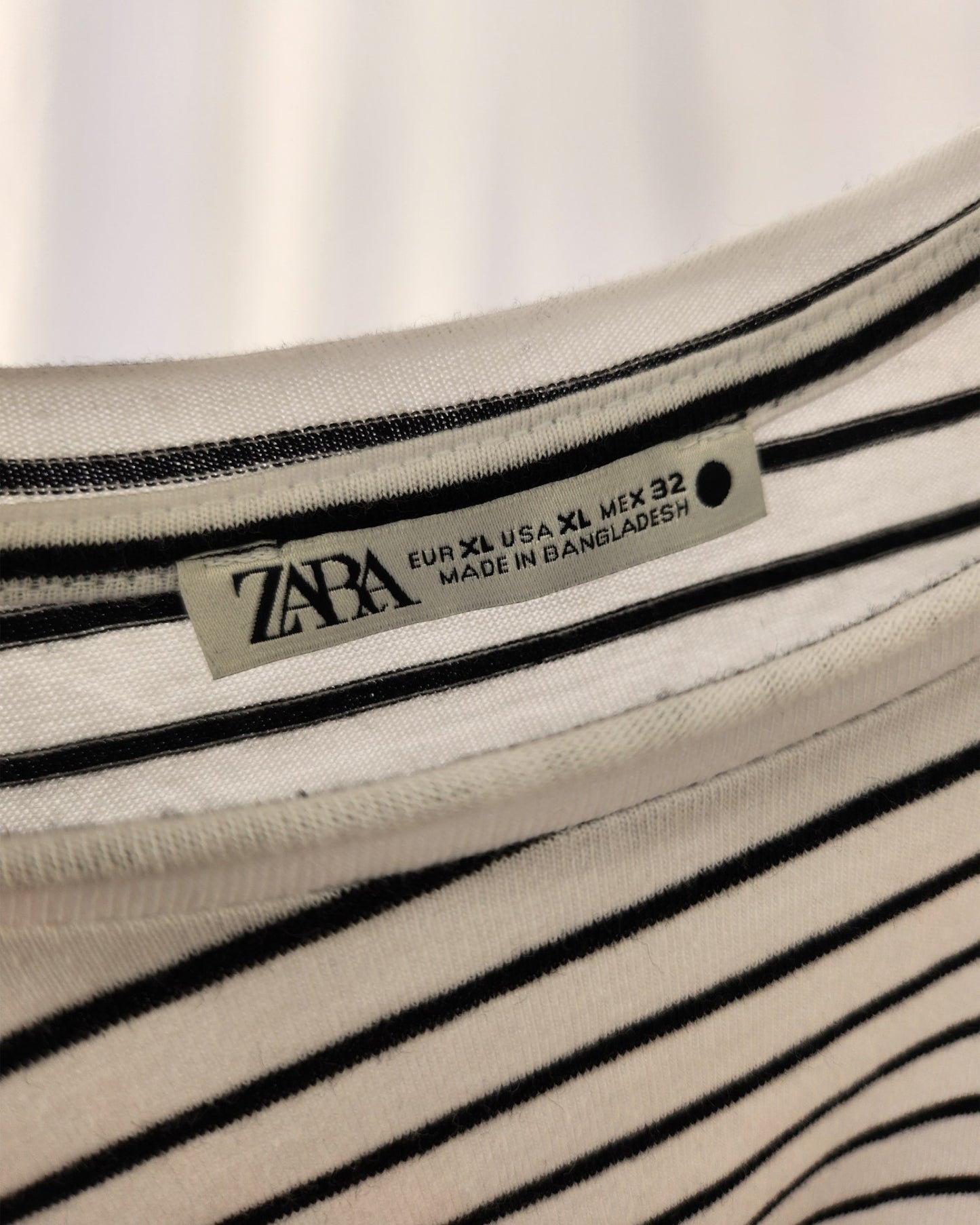 A close-up of a touched out mama label on the Upcycled Breastfeeding & Pumping Stripe Ochre Maxi Dress M/L shows eco-friendly style. Made in Bangladesh, its chic horizontal stripes blend fashion and sustainability seamlessly.