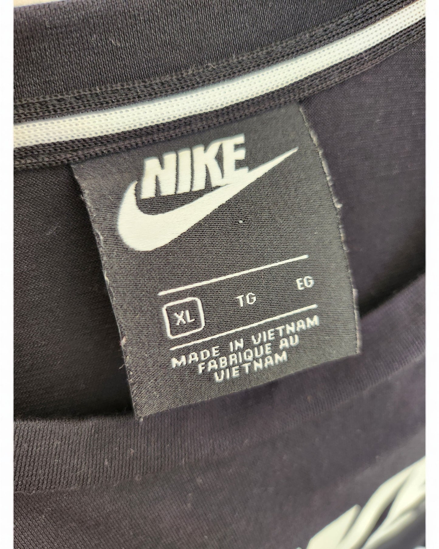 The label on this upcycled touched out mama Nike Maxi Dress in size XL/TG/EG reads MADE IN VIETNAM FABRIQUÉ AU VIETNAM, sewn onto a garment featuring bold white stripes.