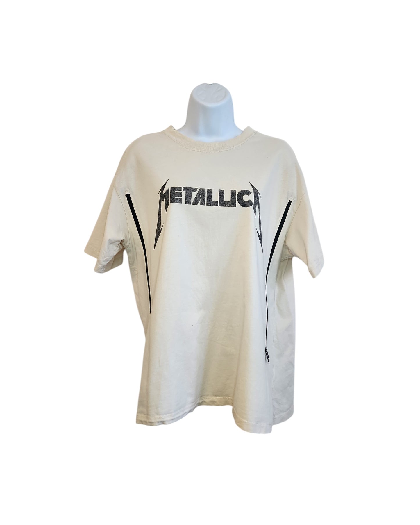On display is the Upcycled Breastfeeding & Pumping Cream Metallica T-shirt (Size S) by touched out mama, featuring bold black Metallica lettering and stylized graphics. This preloved piece highlights a simple design with a classic rock vibe.