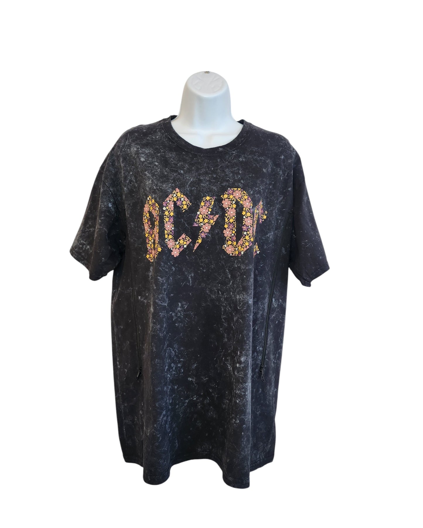 This upcycled black t-shirt by touched out mama features a floral AC/DC print in the center, boasting a marbled texture. Essentially eco-friendly fashion in XL for breastfeeding and pumping, its beautifully showcased on a mannequin.