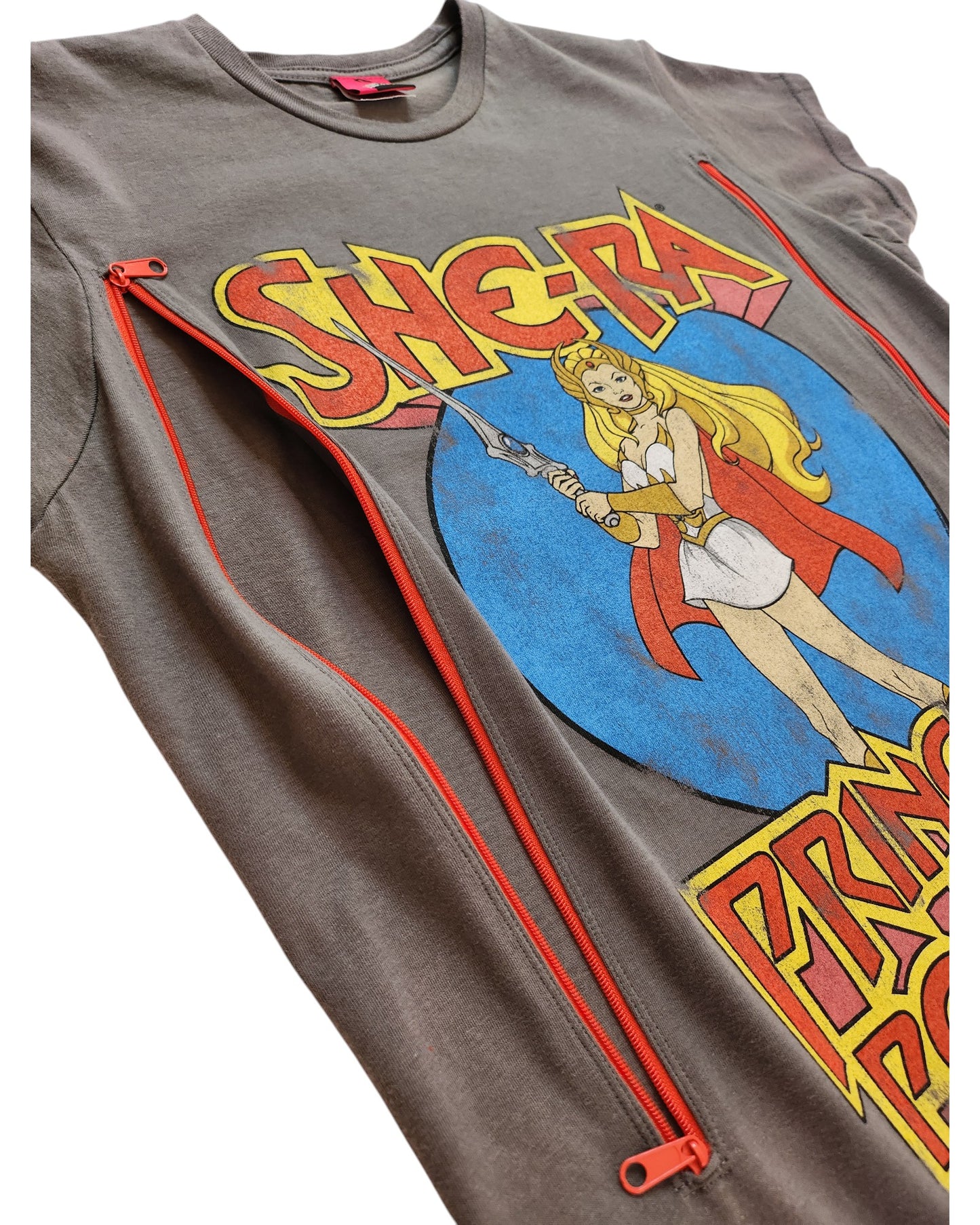 Preowned She-Ra t-shirt by touched out mama in gray, featuring a sword-wielding She-Ra in a vibrant circle design with two unique red decorative zippers near the image. Upcycled for breastfeeding and pumping, size L.