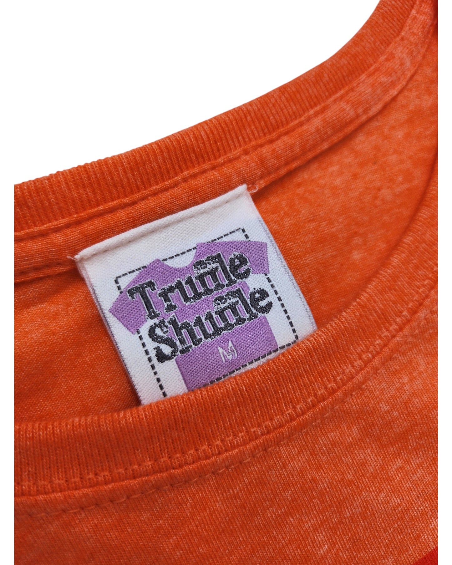 Close-up of an orange Upcycled Breastfeeding & Pumping Transformers t-shirt in size M, featuring a white label with a purple graphic and Truffle Shuffle branding—combining style with eco-friendly fashion.