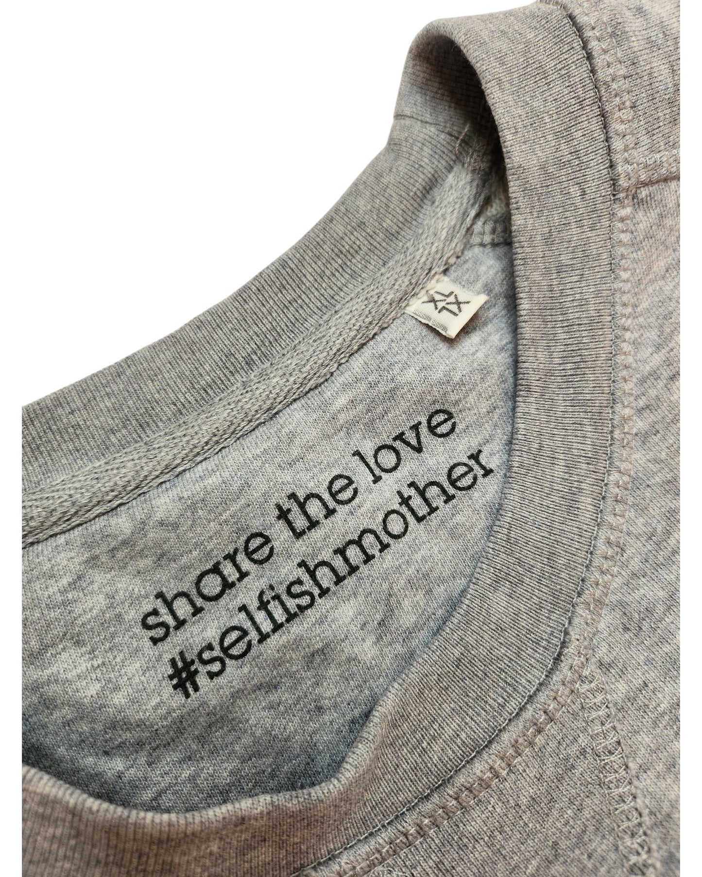 Close-up of the Upcycled Breastfeeding & Pumping Winging It Sweatshirt XL by touched out mama, featuring a gray collar with black share the love #selfishmother text and a fabric tag—an affordable choice for upcycled clothing fans.