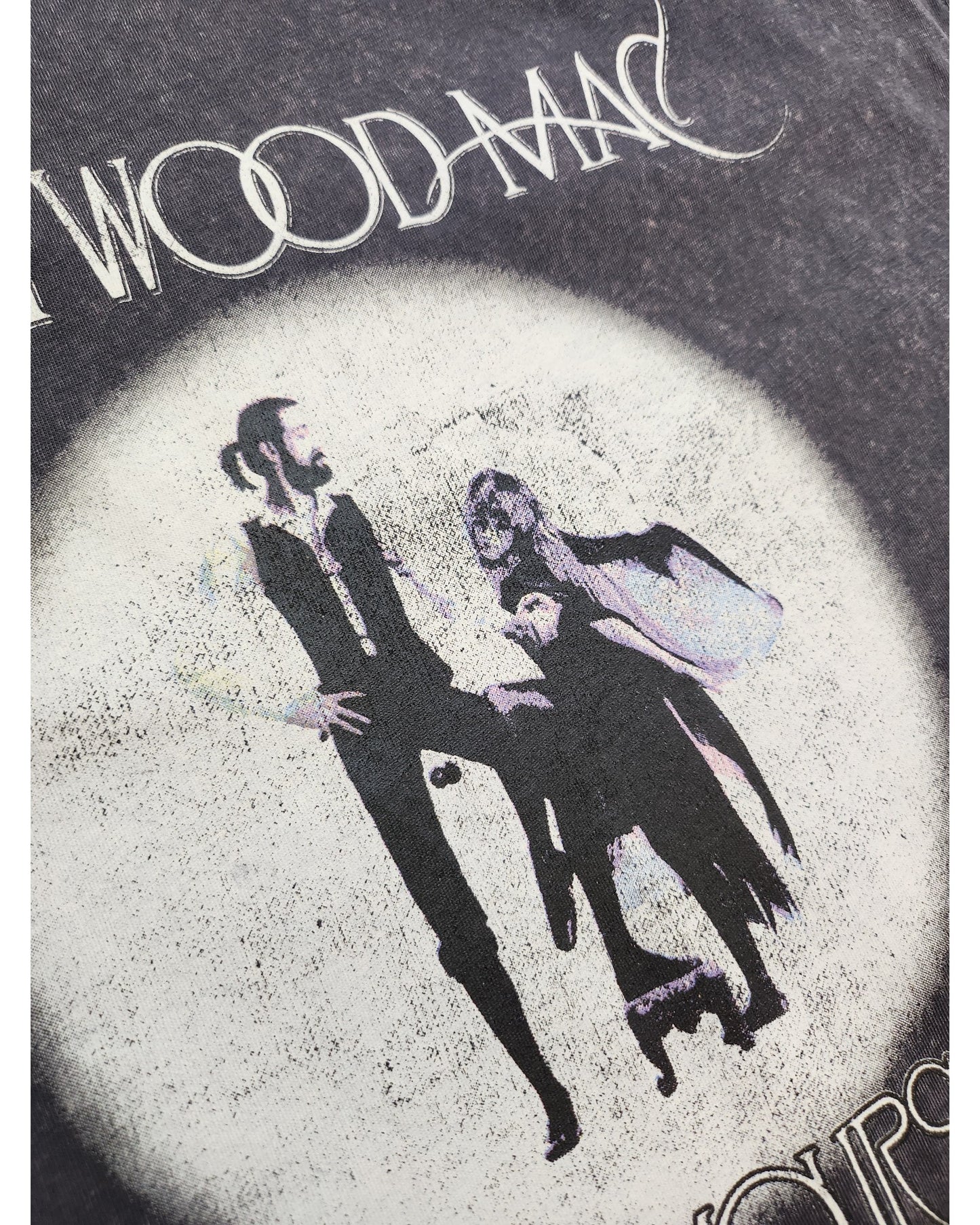 Embrace classic fashion with the Upcycled Breastfeeding & Pumping Fleetwood Mac Rumours T-shirt by touched out mama. Crafted sustainably, it features a vintage-style design of a couple under WOOD MAC on a dark, weathered circle, merging eco-friendly style with timeless charm.