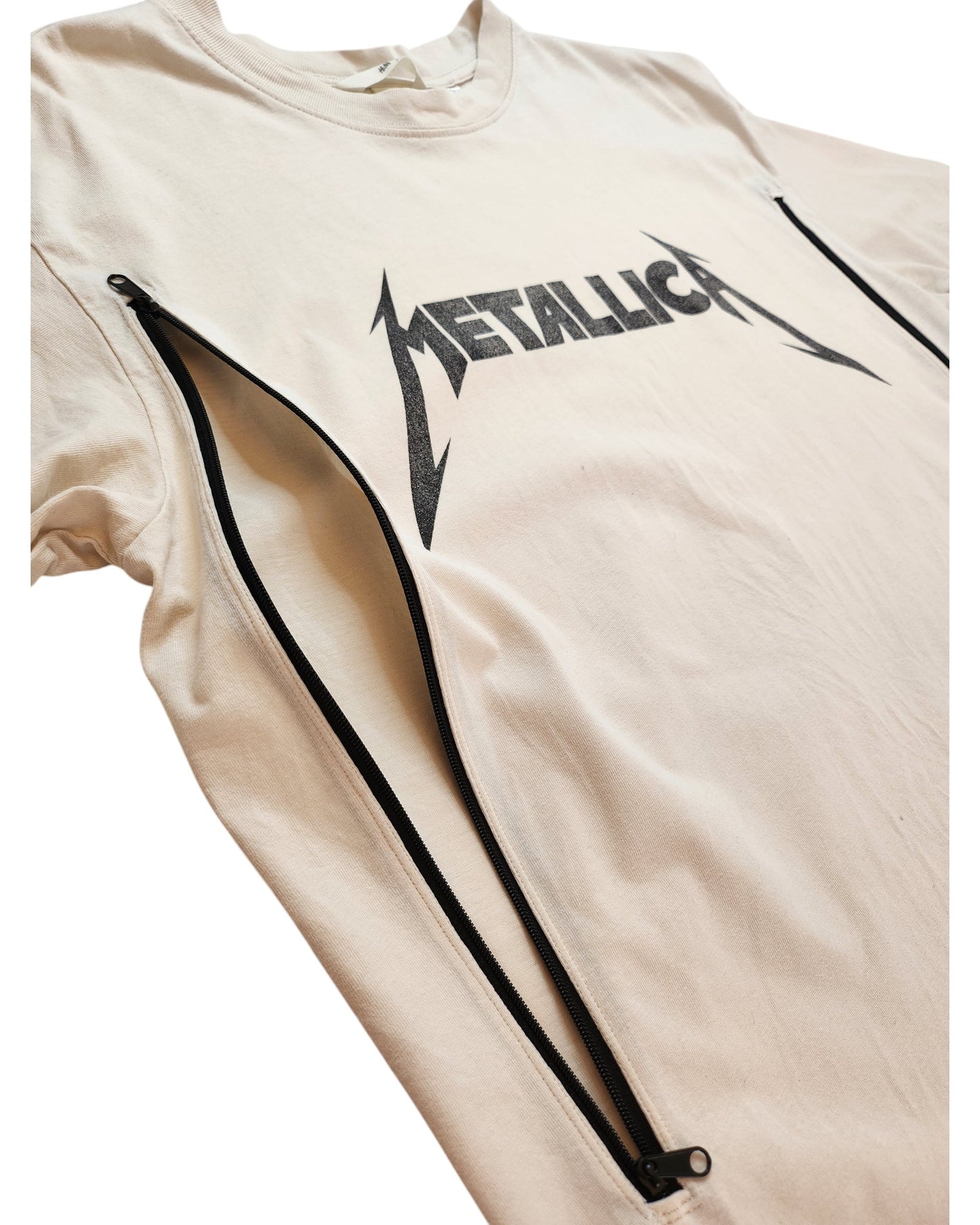 The Upcycled Breastfeeding (Nursing) & Pumping Cream Metallica T-shirt S by touched out mama features a black Metallica logo and vertical black zippers from the shoulders down the sides, blending preloved fashion with modern edge to make a statement in sustainable style.