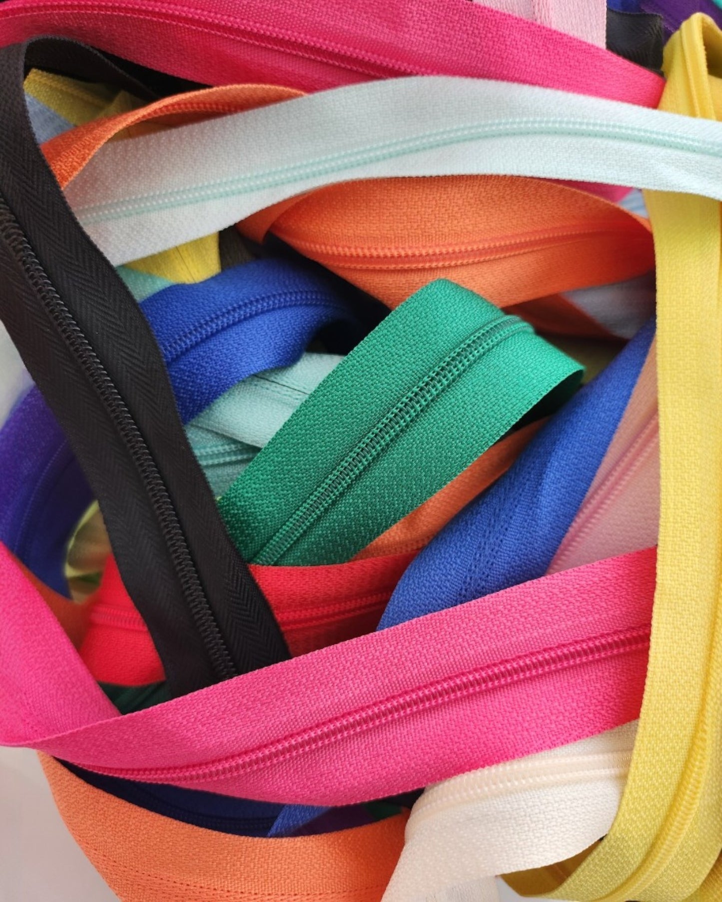 A close-up of colorful zippers, ideal for the touched out mama Custom Breastfeeding-Friendly Upcycling Service, designed specifically for transforming t-shirts.