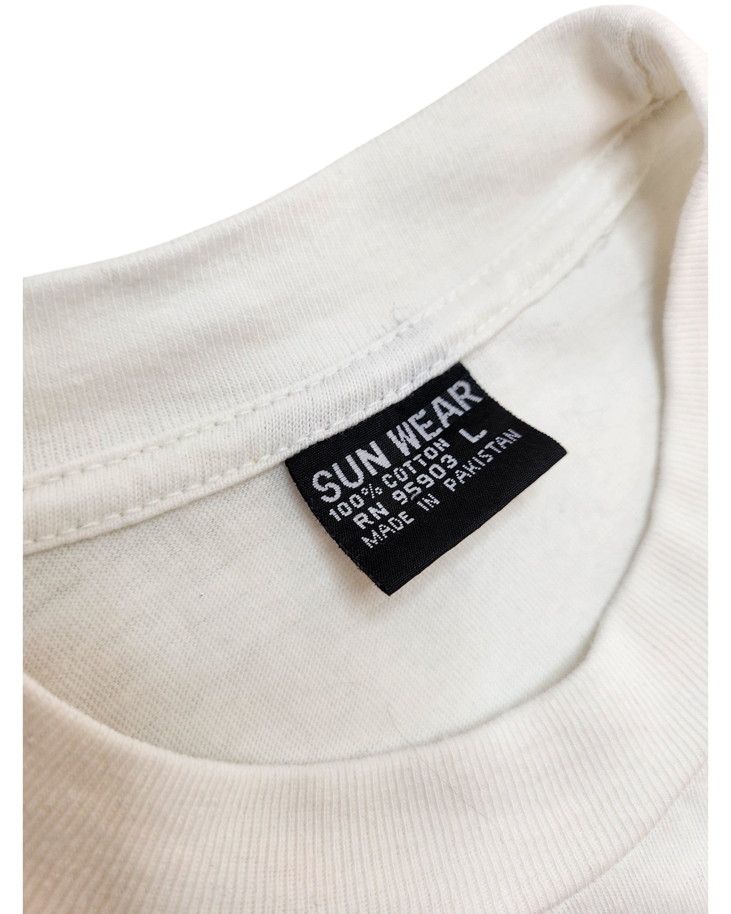 A close-up of a white Sun Wear tag on the Upcycled Breastfeeding & Pumping Times Square t-shirt (L)—an ideal, comfortable preloved shirt made from 100% cotton in Pakistan.