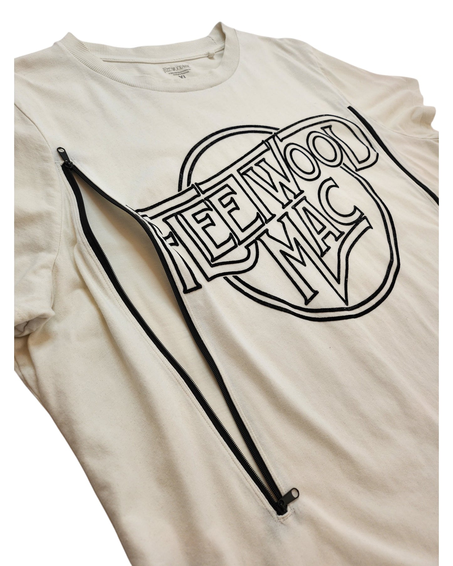 The Fleetwood Mac Upcycled Breastfeeding & Pumping White/Black t-shirt (XL) features black lettering, two diagonal black zippers across the chest for nursing or pumping access, and is crafted from upcycled clothing for sustainability.
