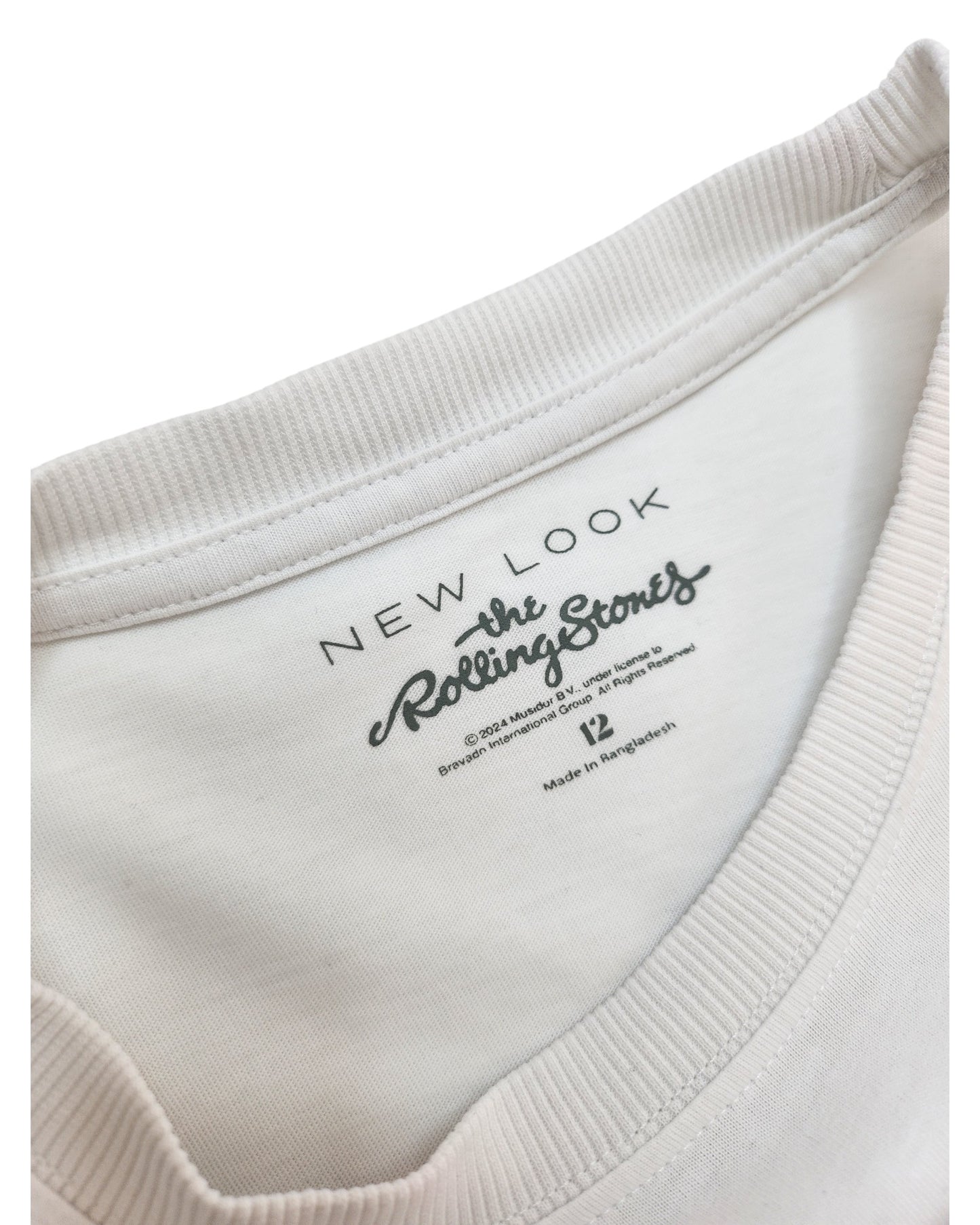 Close-up of the collar on a white New Look Upcycled Breastfeeding & Pumping Rolling Stones T-shirt (UK12), featuring tags and leopard print—perfect for fans of preloved fashion.