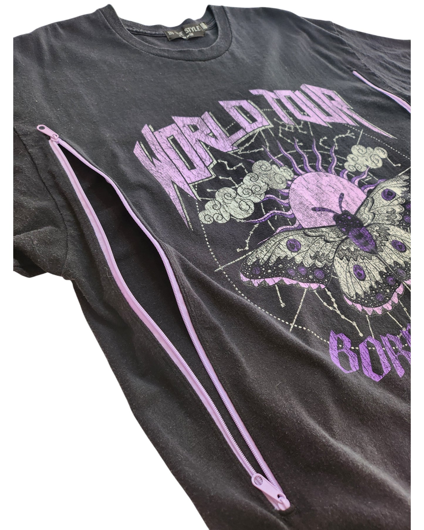 The In the Style Upcycled Breastfeeding & Pumping Black/Purple Butterfly t-shirt UK14/16 features WORLD TOUR text, a butterfly, clouds graphic, and vertical purple zippers on both sides. Made from upcycled clothing for a unique look.