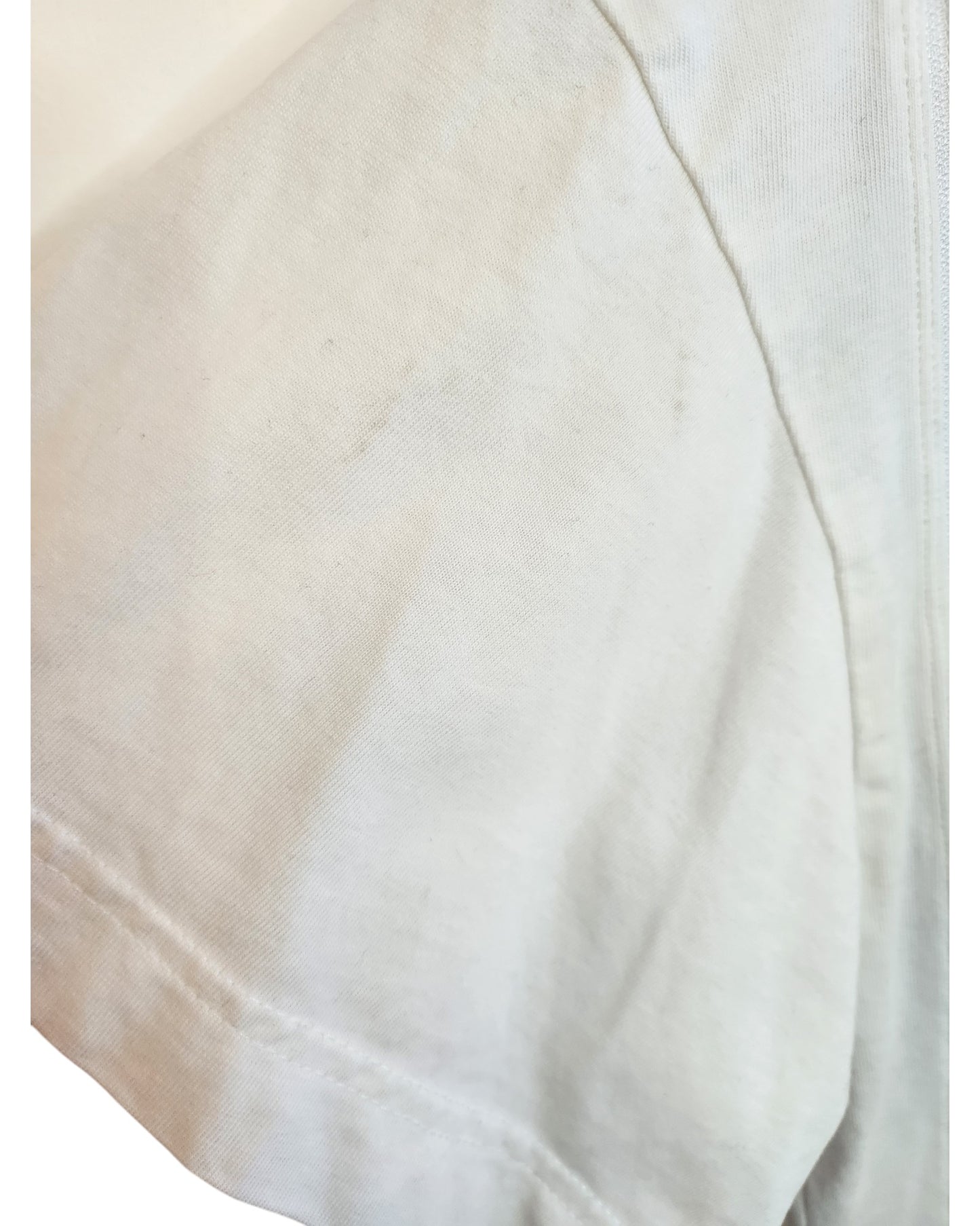 A close-up of the H&M Upcycled Breastfeeding & Pumping Rolling Stones Band t-shirt in white/blue, size L, highlights visible seams, subtle creasing, and unique stitching details that showcase the sustainable fabric’s character.