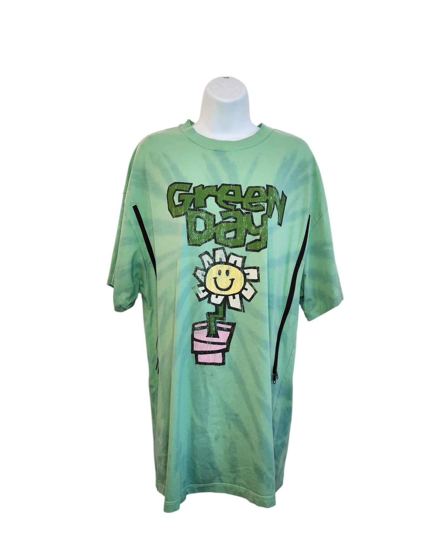 Upcycled H&M Green Day Band breastfeeding/pumping t-shirt (XS) features bold graffiti-style lettering and a smiling flower in a pink pot, displayed on a mannequin against a white background.