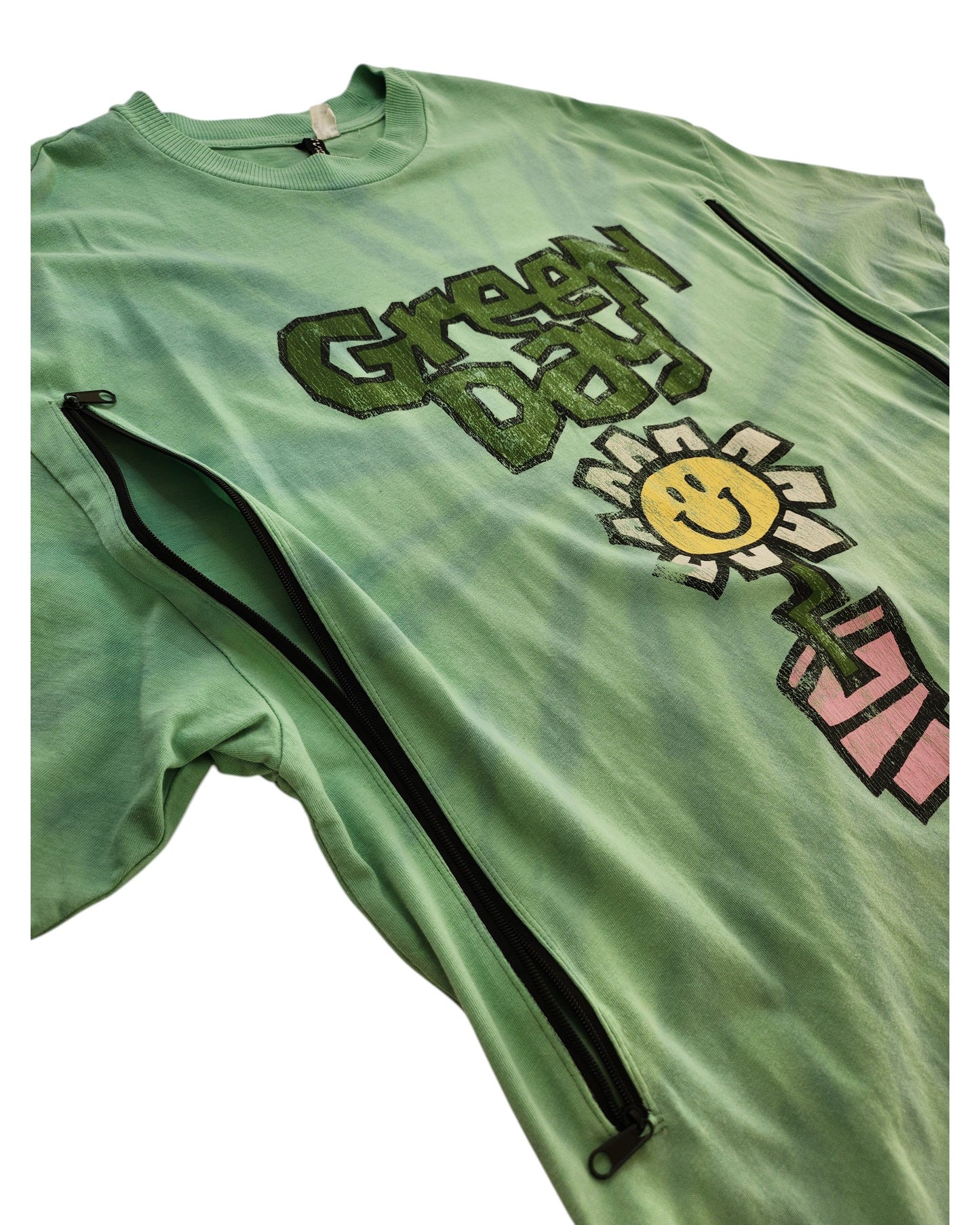 An upcycled H&M Green Day Band t-shirt in XS, designed for breastfeeding and pumping—features green fabric, text, smiling daisy graphic, and two black diagonal zippers; a unique preloved fashion find.
