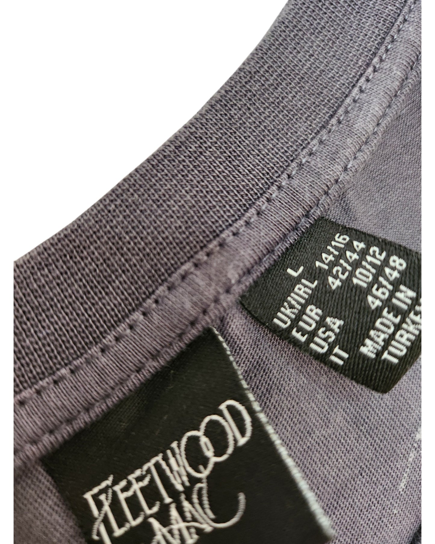 Close-up of a Primark Upcycled Breastfeeding & Pumping Dark Grey Floral Fleetwood Mac t-shirt (L, UK14/16) collar. Visible tags show the Fleetwood Mac print and size info—perfect for fans of unique, preloved maternity wear.