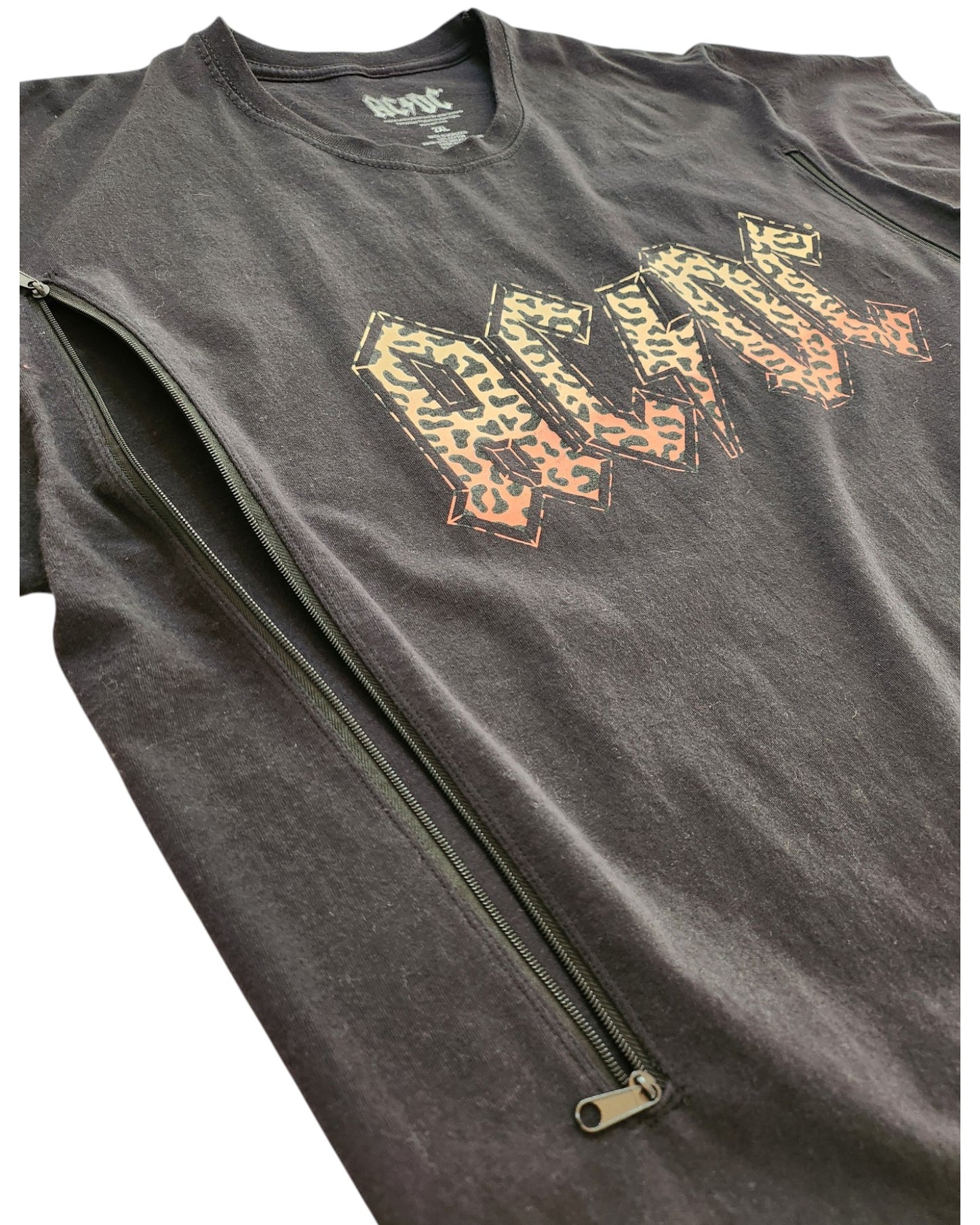 An upcycled AC/DC 2XL band t-shirt for breastfeeding and pumping, featuring bold leopard-print lettering and a diagonal zipper—perfect for preloved fashion fans.