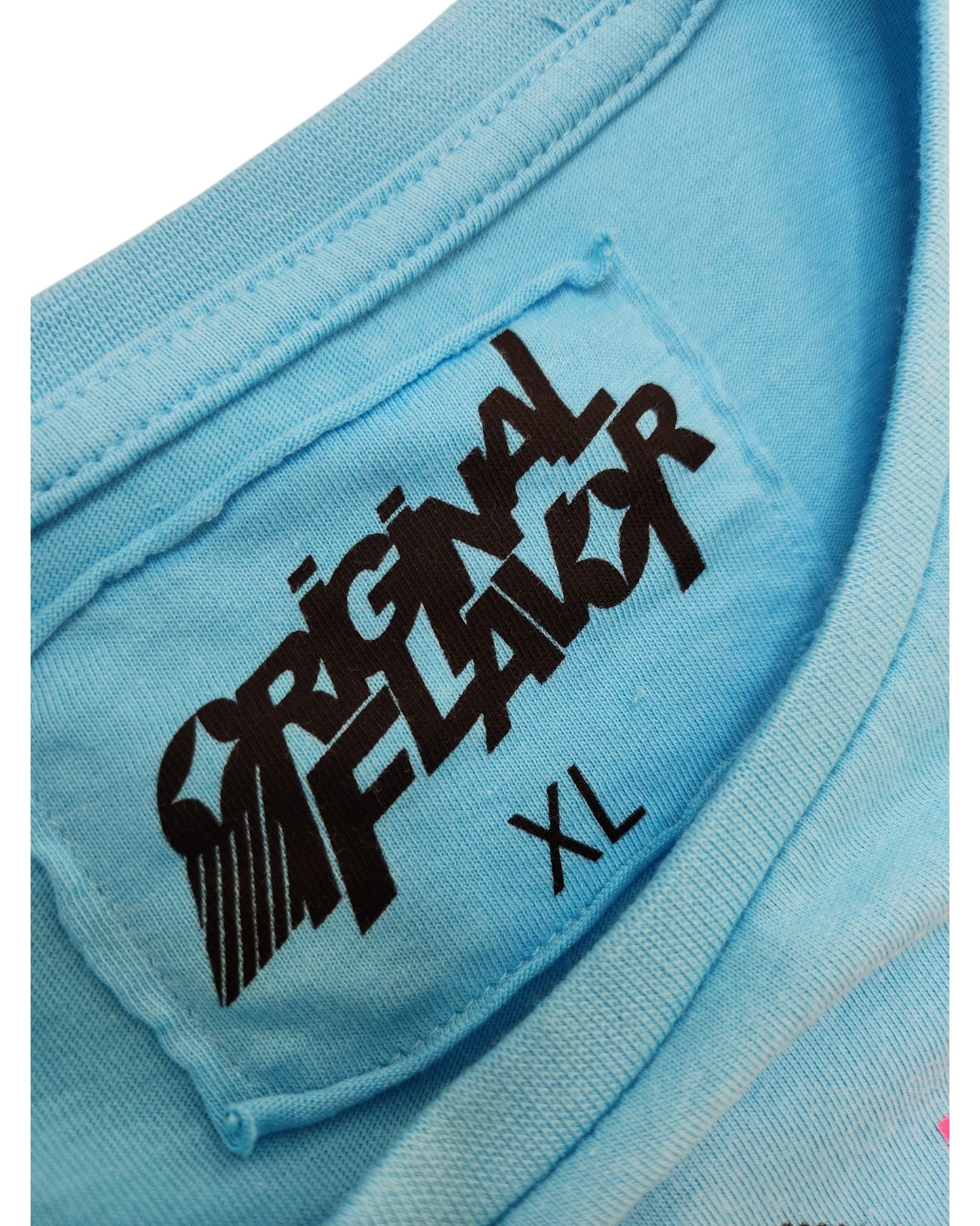 Close-up of a light blue Primark Upcycled Breastfeeding & Pumping Vanilla Ice Ice Baby t-shirt (XL) collar with a sewn-in label—an original, bold find among preloved and upcycled clothing.