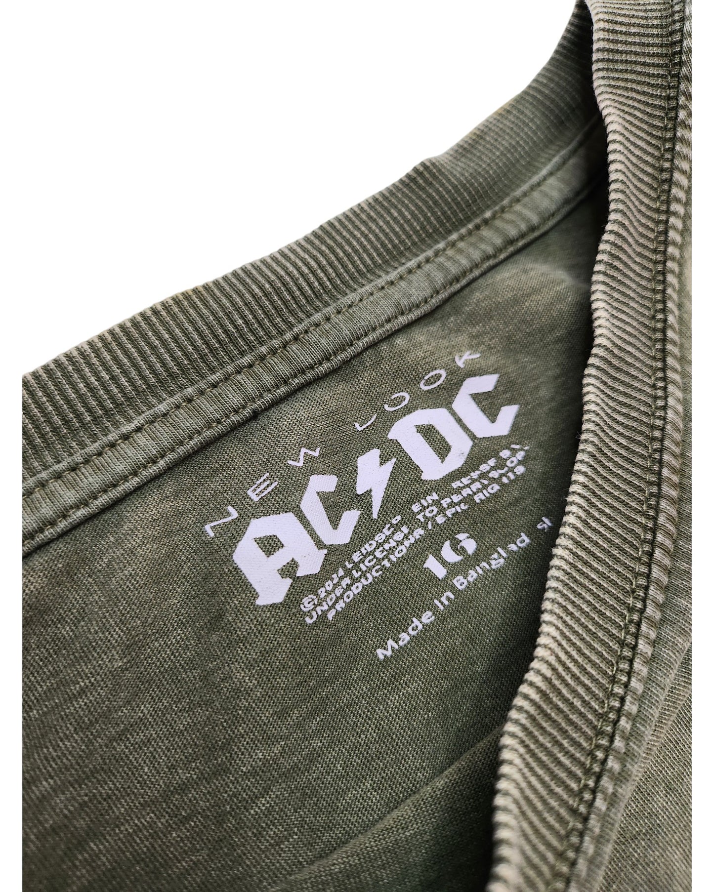 Close-up of an olive green Upcycled Breastfeeding & Pumping Khakhi AC/DC t-shirt UK16 by New Look, showing a white printed label with brand, size, Made in Bangladesh, and eco-friendly care instructions.