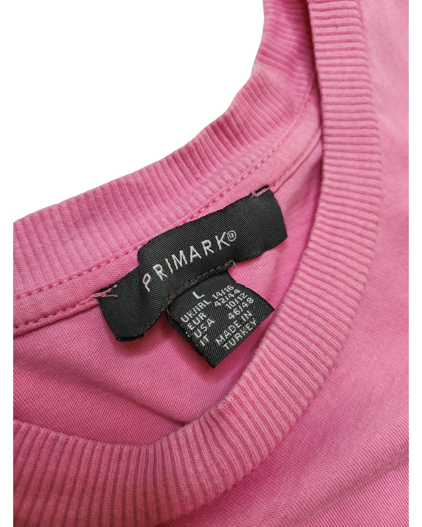 Close-up of the neckline of the Upcycled Breastfeeding & Pumping Pink Take Care t-shirt (L/UK14/16) by Primark, featuring a black label with size and fabric details in white text, highlighting this eco-friendly piece.
