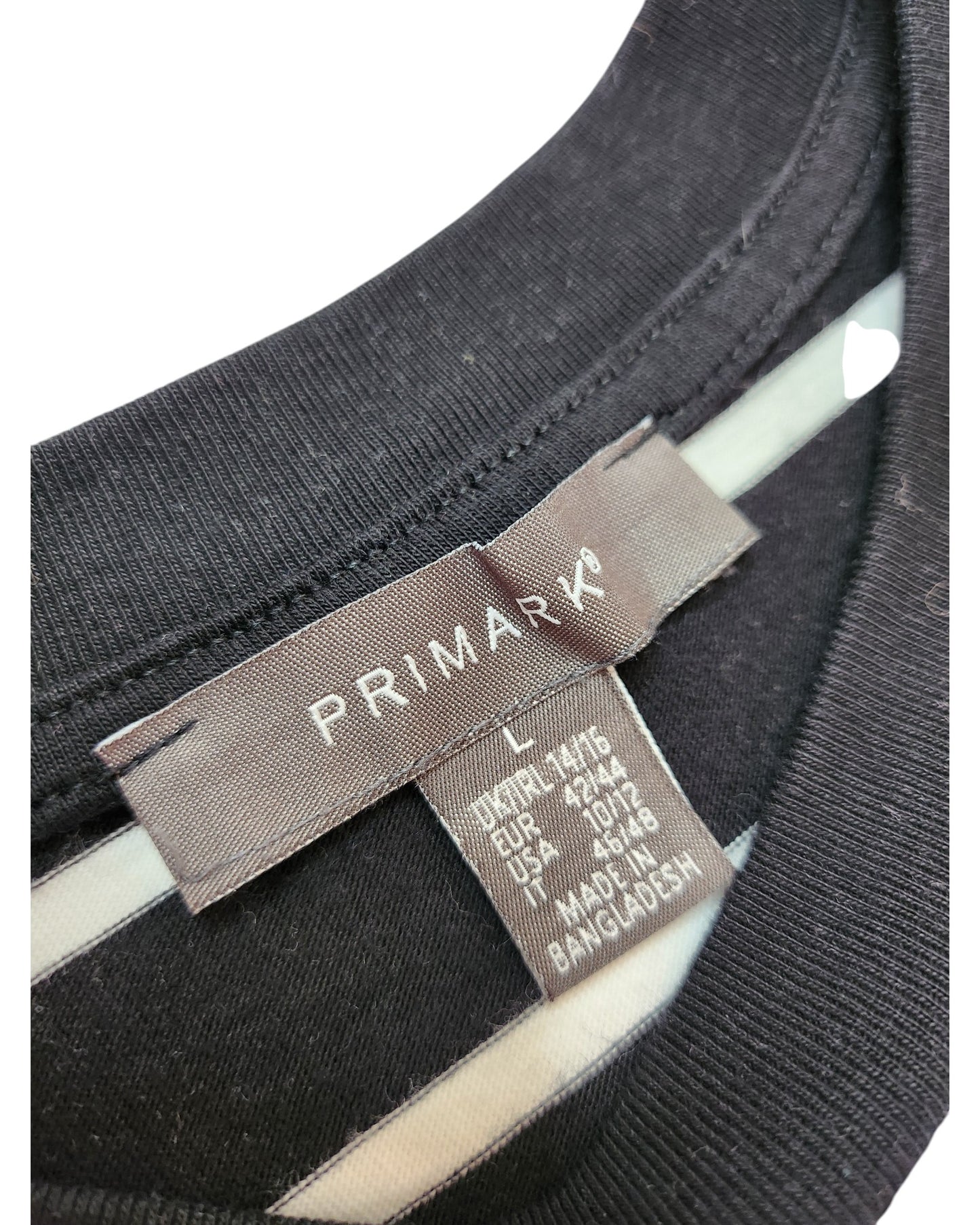 Close-up of a clothing label on a Primark Upcycled Breastfeeding & Pumping Black/White Stripe T-shirt (L, UK14/16). The label displays international sizing, Made in Bangladesh, reflecting the brand’s eco-friendly focus.