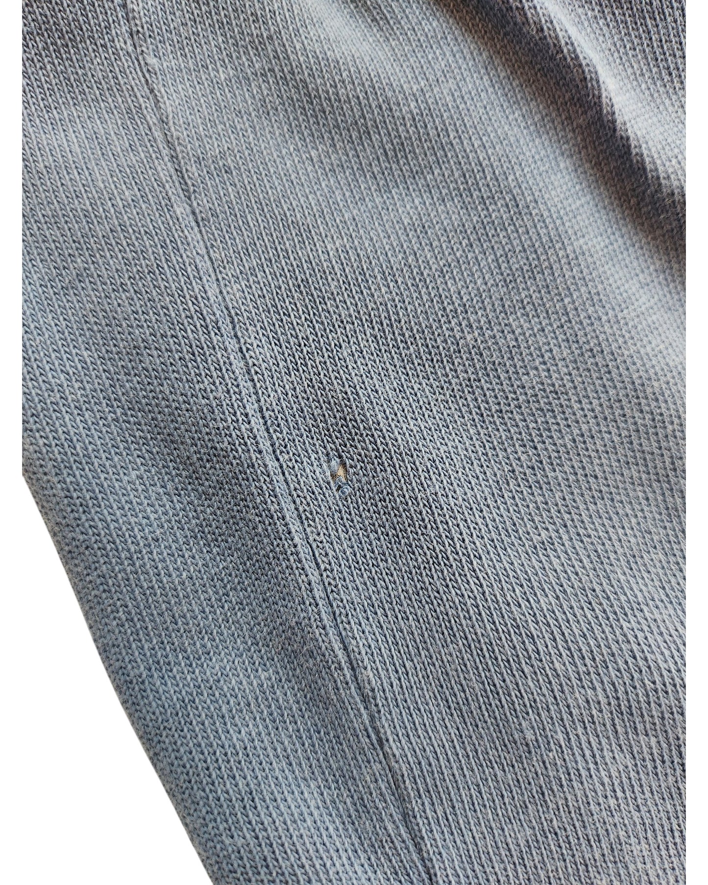 A close-up of the ZARA Upcycled Breastfeeding & Pumping Snoopy Blue t-shirt (M) reveals a small hole near the seam, highlighting a minor flaw that adds to this preloved shirt’s unique character and story.