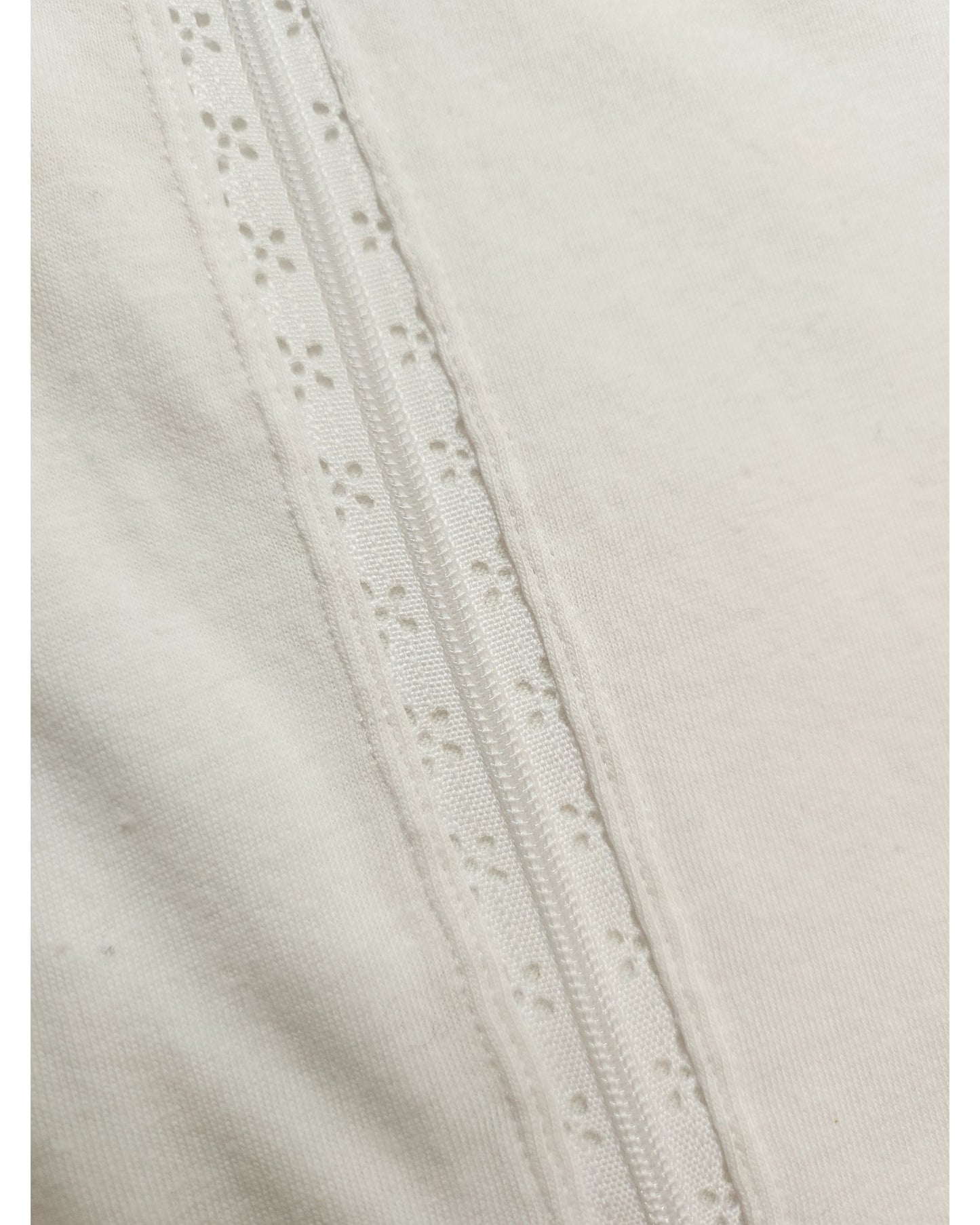 Close-up of Pep & Cos Upcycled Breastfeeding & Pumping Plain White Shoulder Fringing t-shirt UK12, showing its eco-friendly fabric and decorative lace trim with small flower cutouts sewn vertically for visible texture and detail.