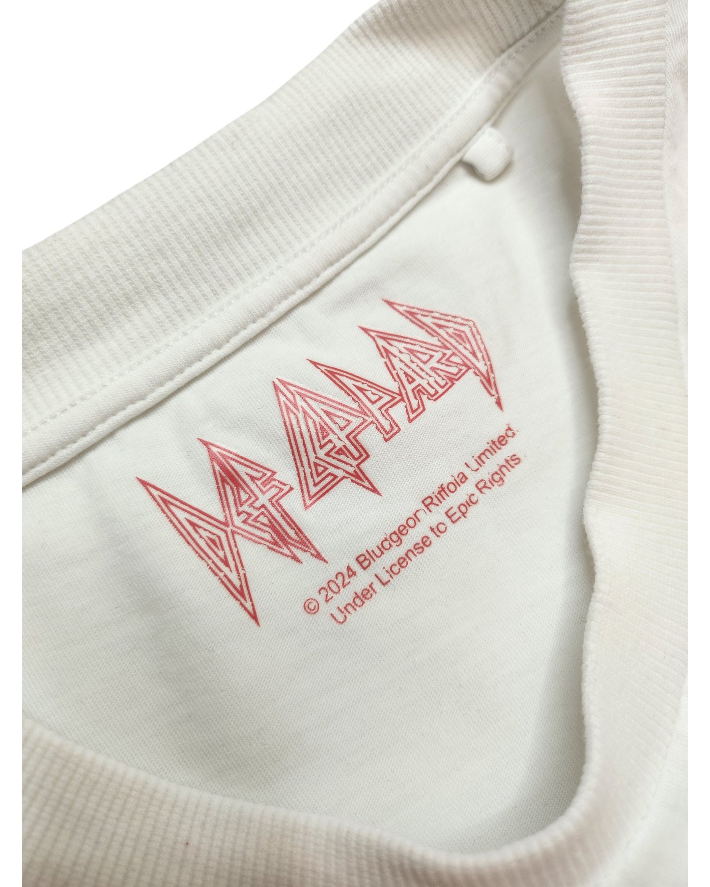 Close-up of the inside collar of a Def Leppard upcycled breastfeeding & pumping white/pink t-shirt (L), featuring the red logo and copyright text—a unique Preloved find blending style with function.