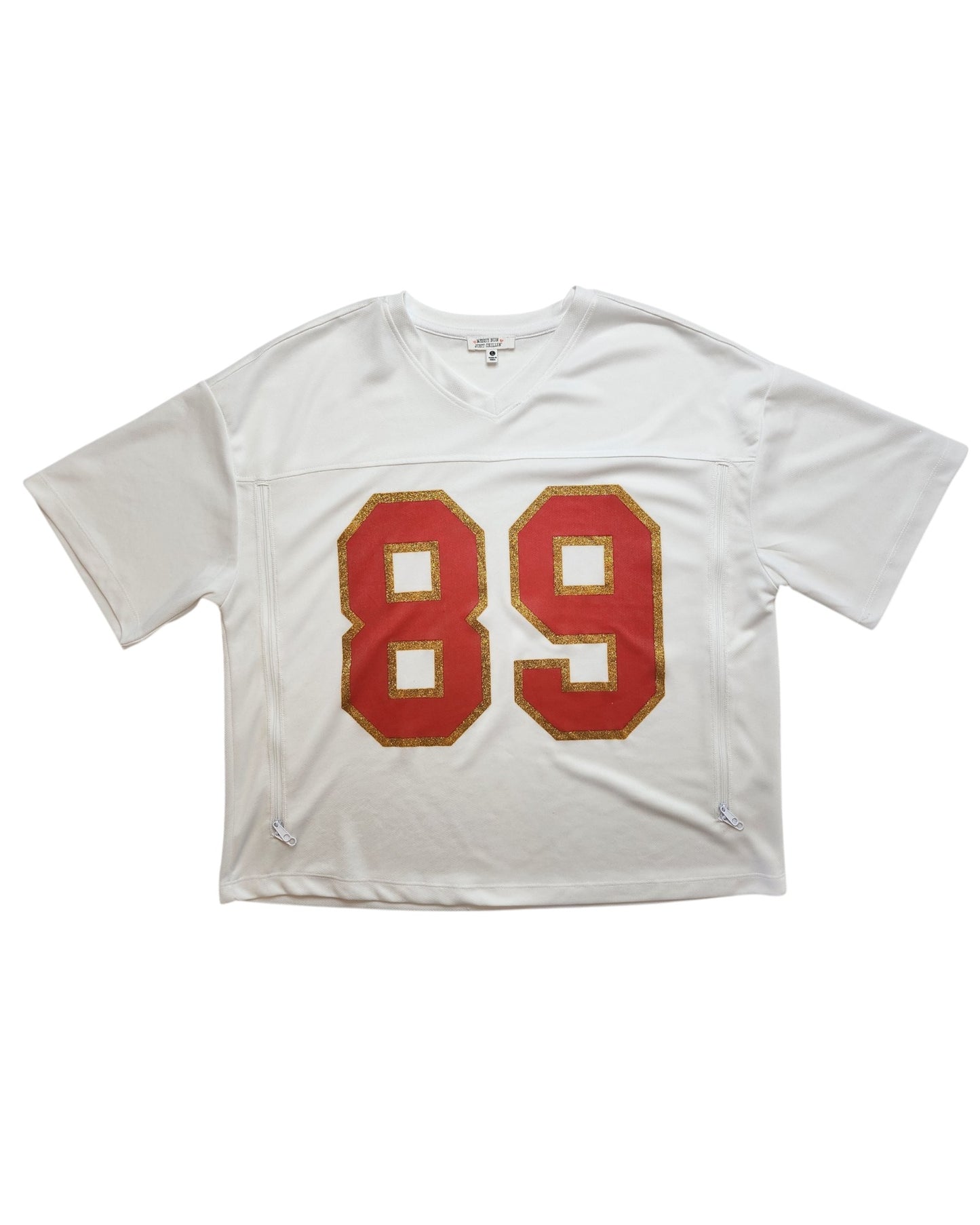 Add sporty flair to your preloved style with this Messy Bun Just Chillin Upcycled Breastfeeding & Pumping 89 Swiftie Football Jersey t-shirt (size L) featuring bold red and gold numbers on a white short-sleeve design.