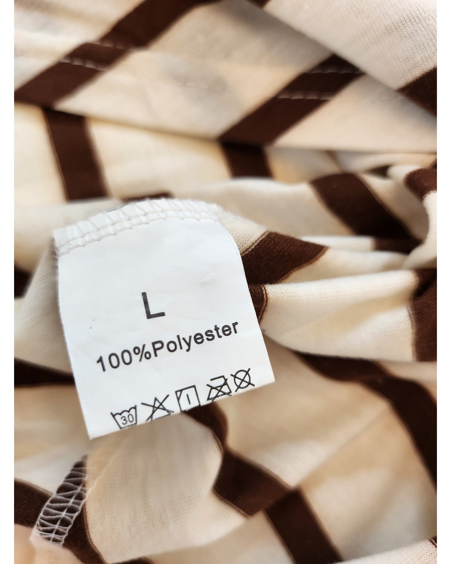 A close-up of the TikTok Upcycled Breastfeeding & Pumping Cream/Brown Stripe Dress label (Size L, 100% Polyester) shows laundry symbols: machine wash at 30°C, do not bleach, and do not iron. Highlights eco-friendly preloved fashion.