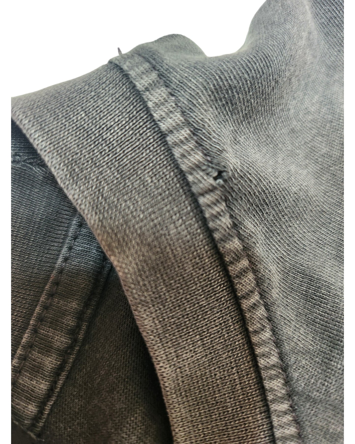 Close-up of the Primark Upcycled Breastfeeding & Pumping Nirvana Band T-shirt (XS, UK6/8) in dark grey/red floral. Thick seam and stitching details highlight the denim-like textured fabric under soft lighting on a white background.