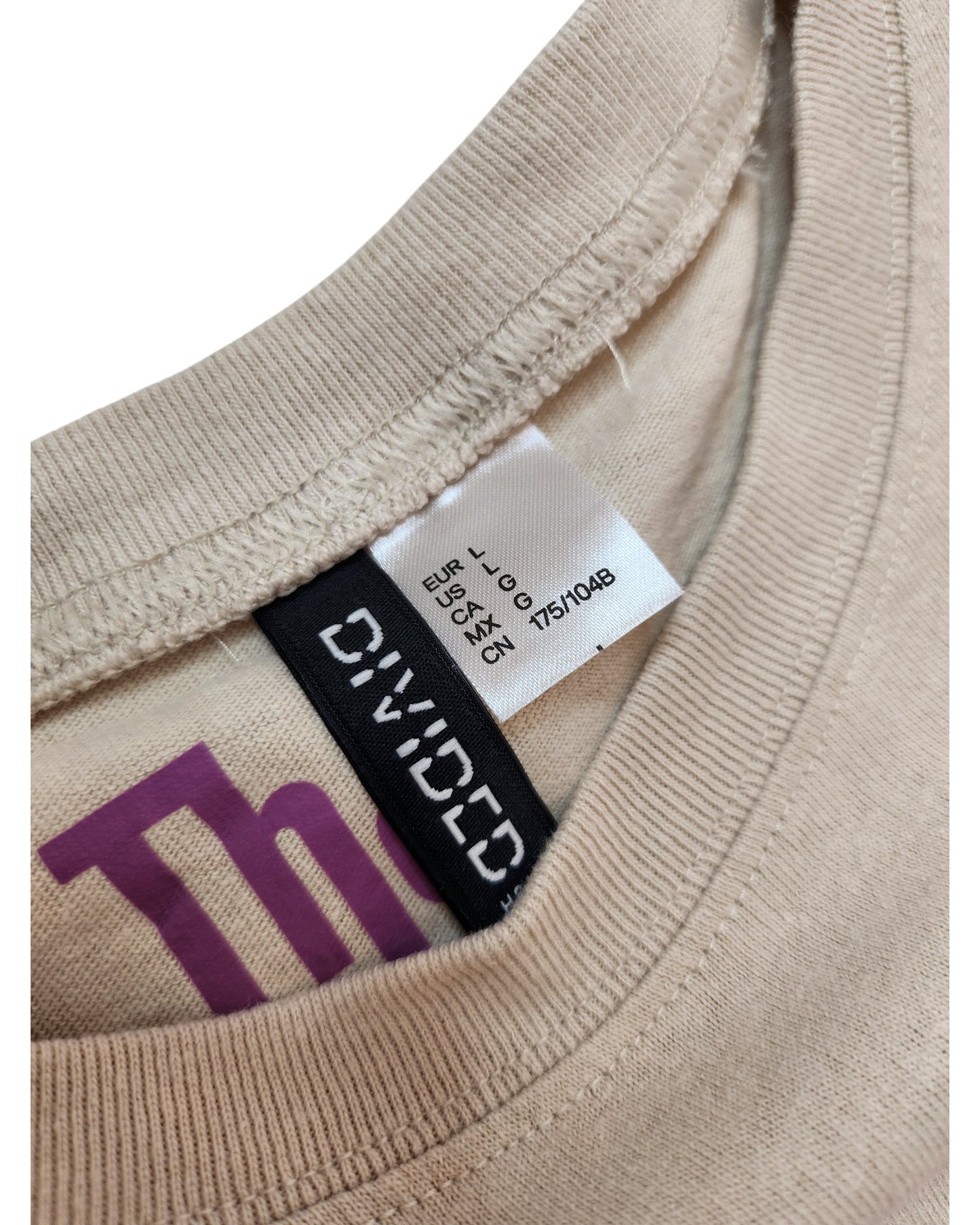 Close-up of a beige Upcycled Breastfeeding & Pumping The Who Band t-shirt (L), featuring an H&M brand tag—a stylish, eco-friendly choice for nursing and pumping moms.