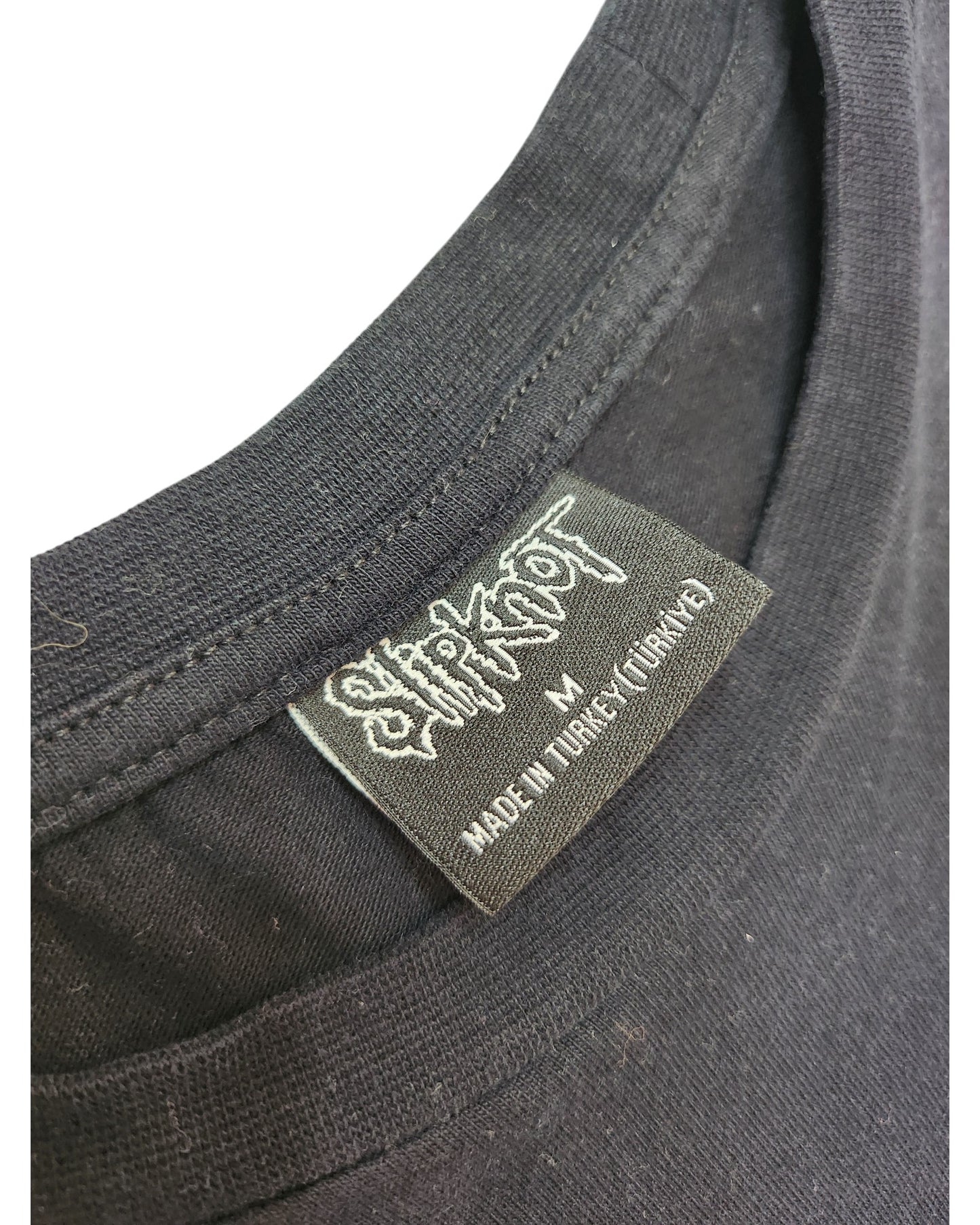 Close-up of a black t-shirt collar with a Primark label reading Upcycled Breastfeeding & Pumping Black/Blue Slipknot Band t-shirt M, highlighting eco-friendly, thoughtfully crafted materials.
