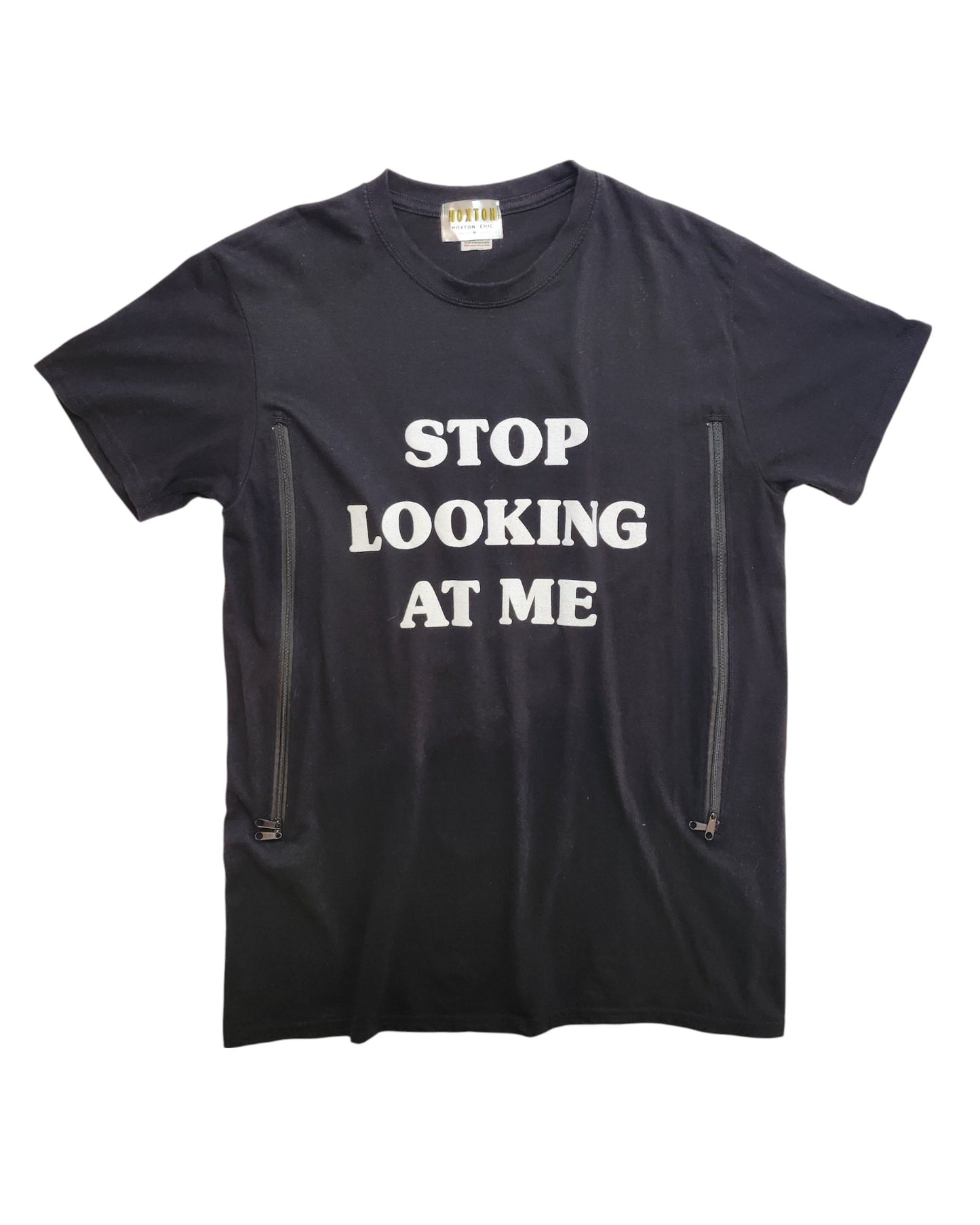 The Hoxton Chic Upcycled Breastfeeding & Pumping Stop Looking t-shirt (M) is made from eco-friendly materials and features bold white STOP LOOKING AT ME text plus two vertical zippers near the bottom for nursing or pumping ease.