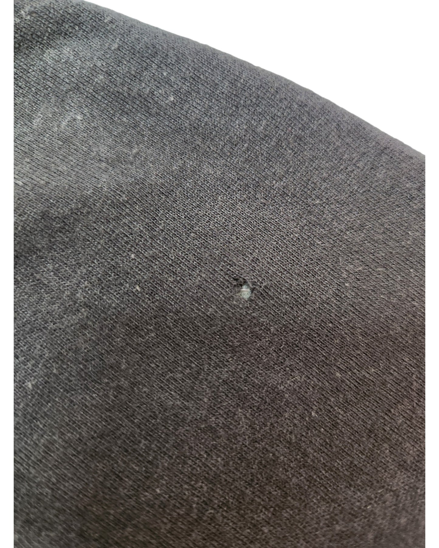 Close-up of the Hoxton Chic Upcycled Breastfeeding & Pumping Stop Looking t-shirt in dark gray (size M), showing a small hole, minor wear, and some lint on the fabric.